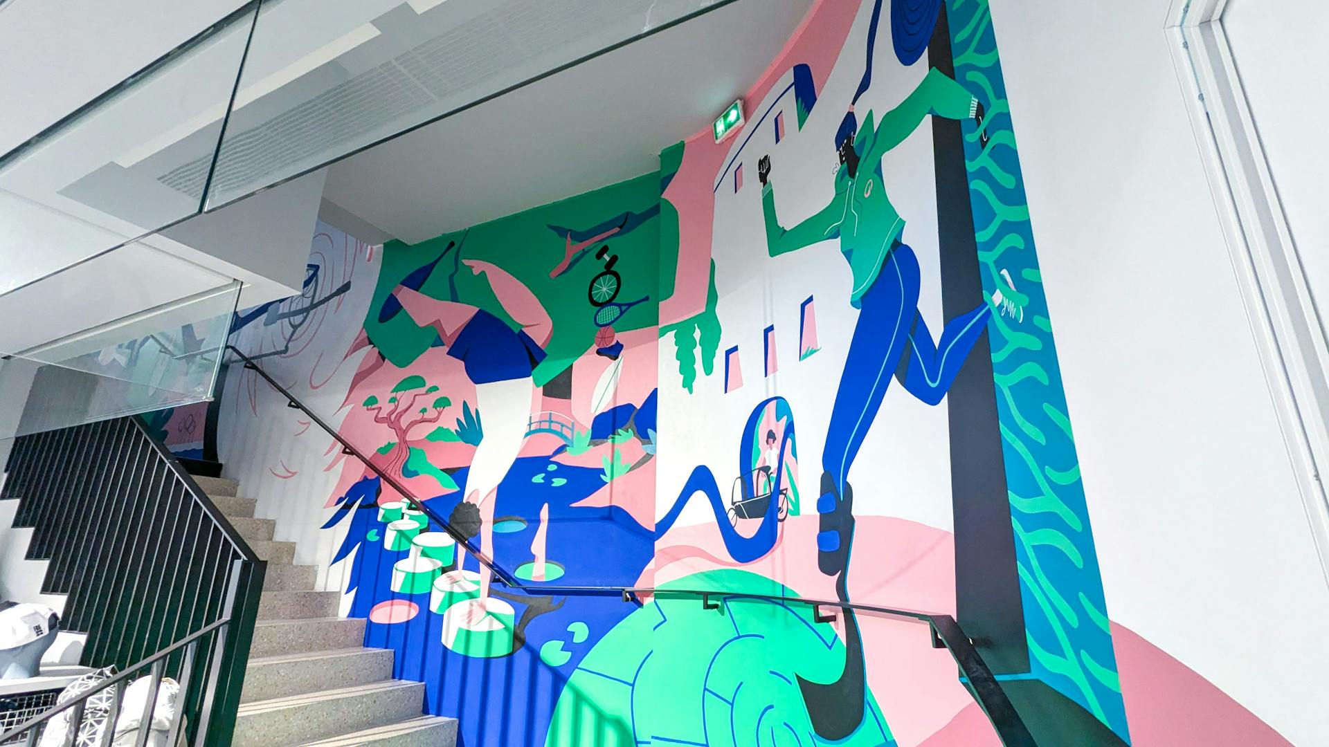 Une fresque de l'agence de design graphique Studio Katra au sein du Décathlon City de Nantes, représentant une coureuse traversant un portail et un gymnaste.
