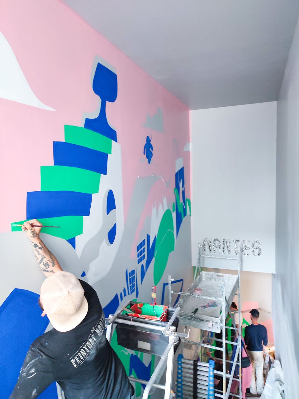 Les équipes des entreprises Studio Katra et Peinture Nantaise réalisent la fresque au sein du nouveau Décathlon City de Nantes.