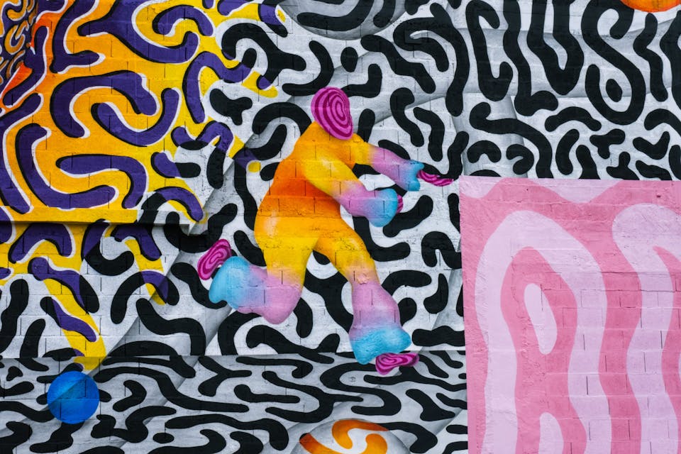 Un espace industriel transformé par une fresque street art de l'artiste Ocü et de l'agence de design Studio Katra, formant un terrain de design actif destiné à la pratique du handball gaélique. On y voit de nombreux motifs psychédéliques aux couleurs vives et un personnage courant vers une balle.