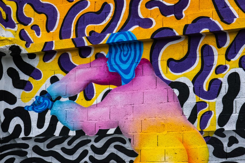 Un espace industriel transformé par une fresque street art de l'artiste Ocü et de l'agence de design Studio Katra, formant un terrain de design actif destiné à la pratique du handball gaélique. On y voit de nombreux motifs psychédéliques aux couleurs vives ainsi qu'un personnage pratiquant le "One Wall".