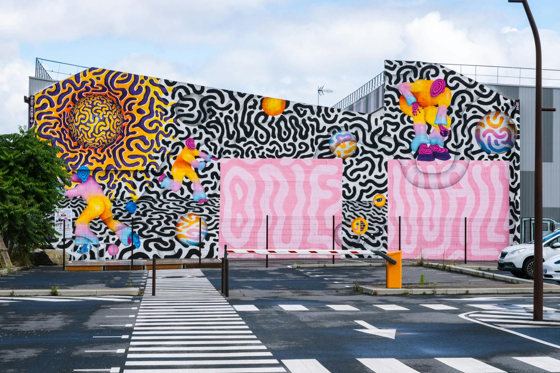 Un espace industriel transformé par une fresque street art de l'artiste Ocü et de l'agence de design Studio Katra, formant un terrain de design actif destiné à la pratique du handball gaélique. On y voit de nombreux motifs psychédéliques aux couleurs vives, des personnages pratiquant la discipline ainsi que l'inscription "One Wall".
