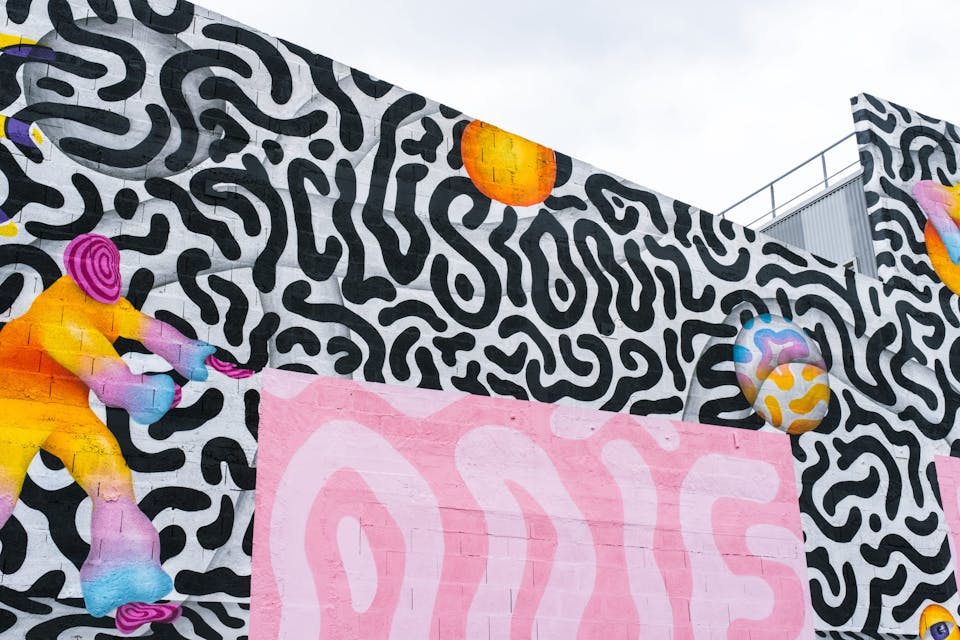 Un espace industriel transformé par une fresque street art de l'artiste Ocü et de l'agence de design Studio Katra, formant un terrain de design actif destiné à la pratique du handball gaélique. On y voit de nombreux motifs psychédéliques aux couleurs vives, des personnages pratiquant la discipline ainsi que l'inscription "Inclusion".