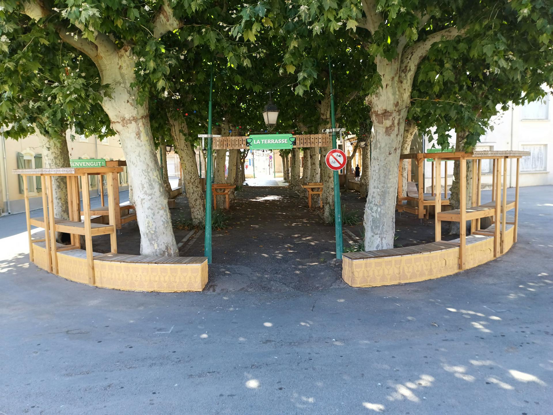 L'entrée de la nouvelle terrasse en bois d'extérieur, aménagée dans le village d'Argeliers sur la promenade Marcelin Albert par l'agence de design Studio Katra.