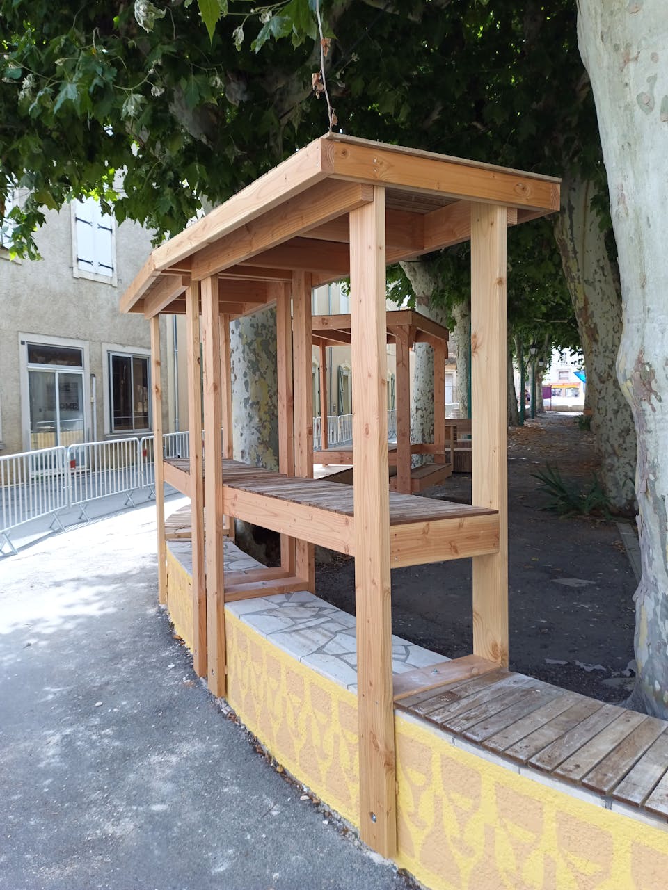 Une terrasse extérieure en bois réalisée sur la promenade Marcelin Albert du village d'Argeliers, par l'agence de design Studio Katra.