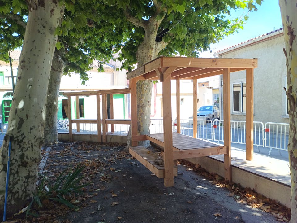 Une terrasse extérieure en bois réalisée sur la promenade Marcelin Albert du village d'Argeliers, par l'agence de design Studio Katra.