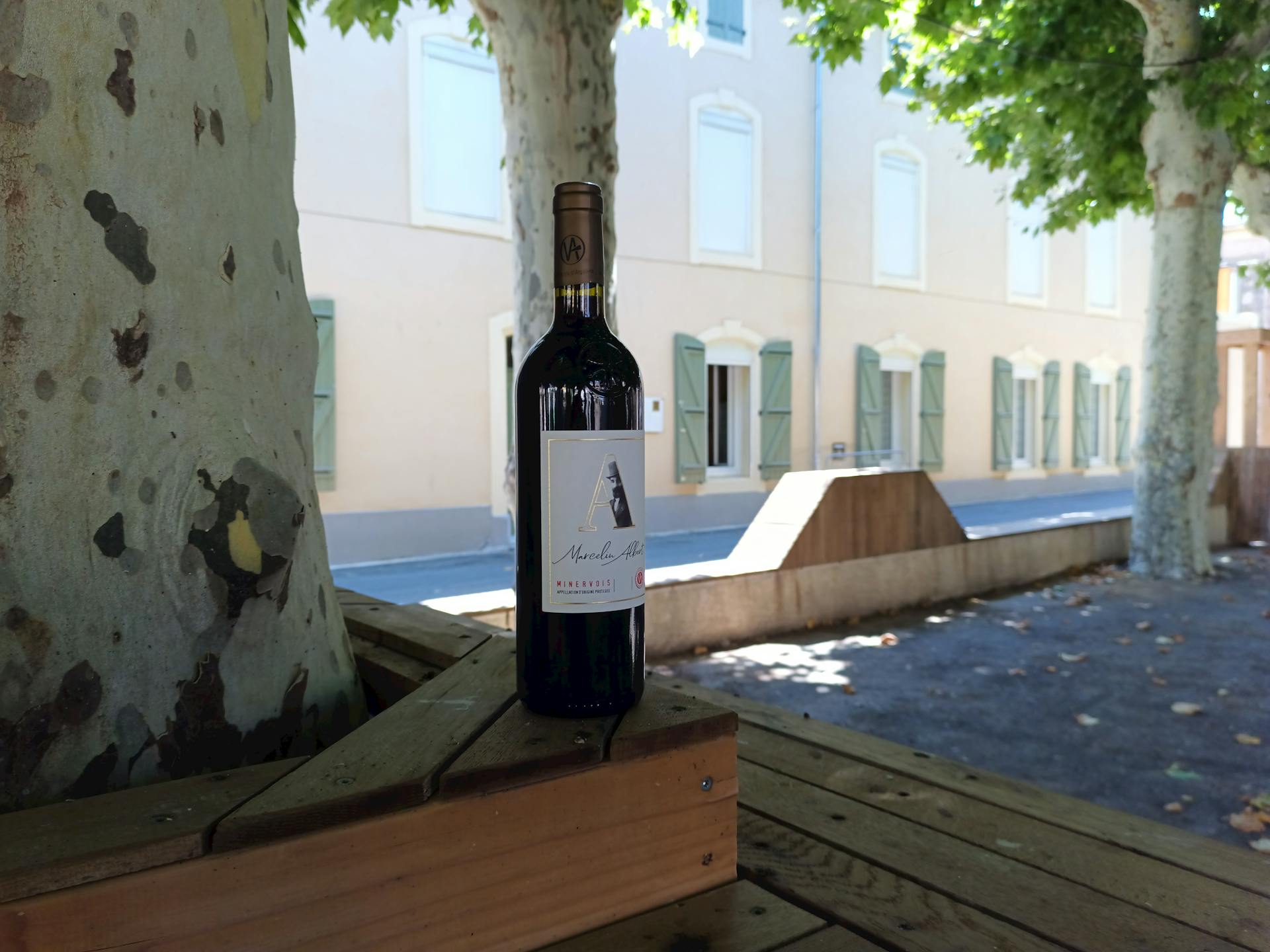 Une bouteille de vin posée sur la terrasse de la promenade Marcelin Albert d'Argeliers