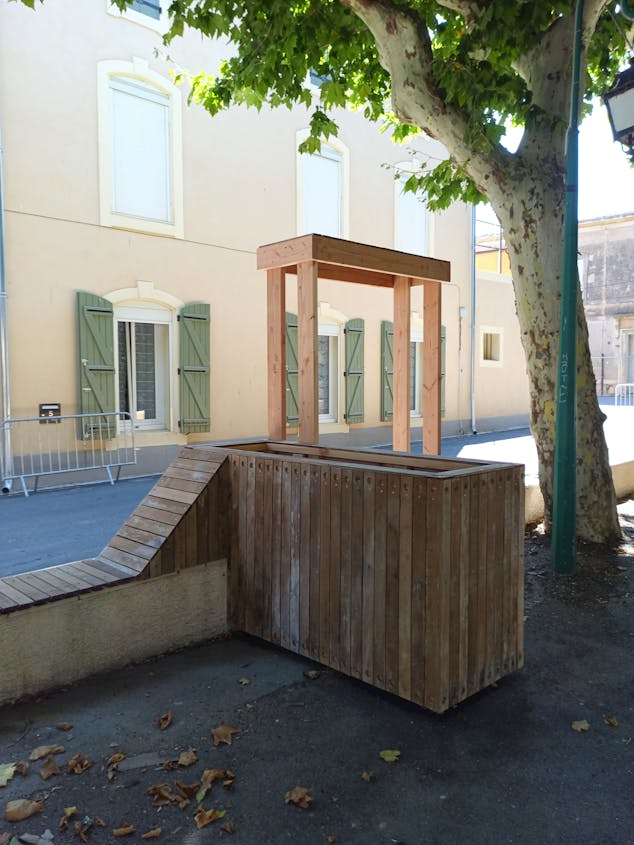 Une terrasse extérieure en bois réalisée sur la promenade Marcelin Albert du village d'Argeliers, par l'agence de design Studio Katra.