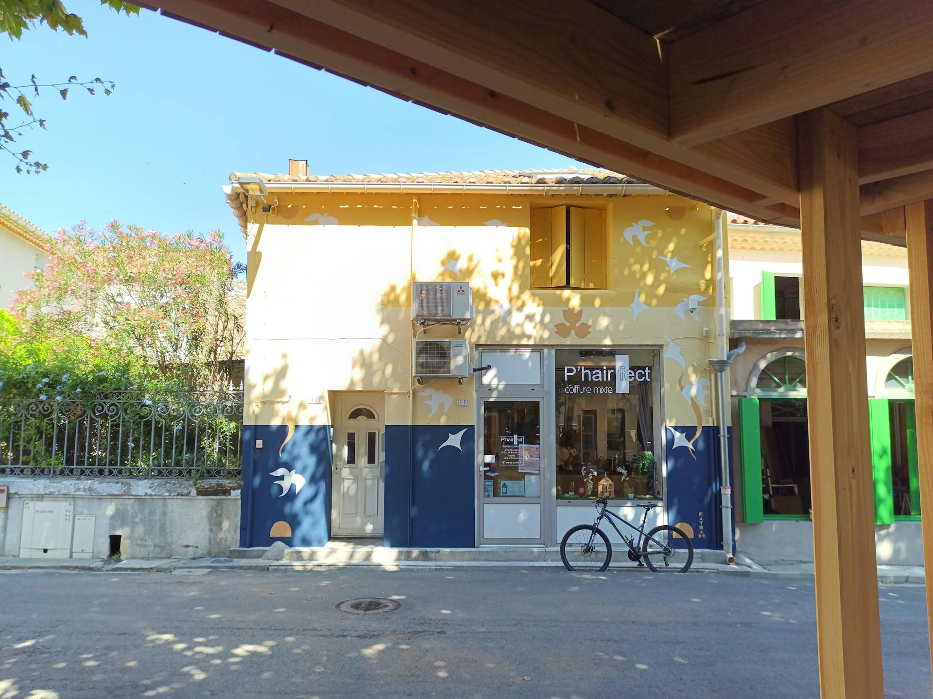 Un salon de coiffure peint aux couleurs et aux motifs de la promenade Marcelin Albert du village d'Argeliers par l'agence de design Studio Katra.
