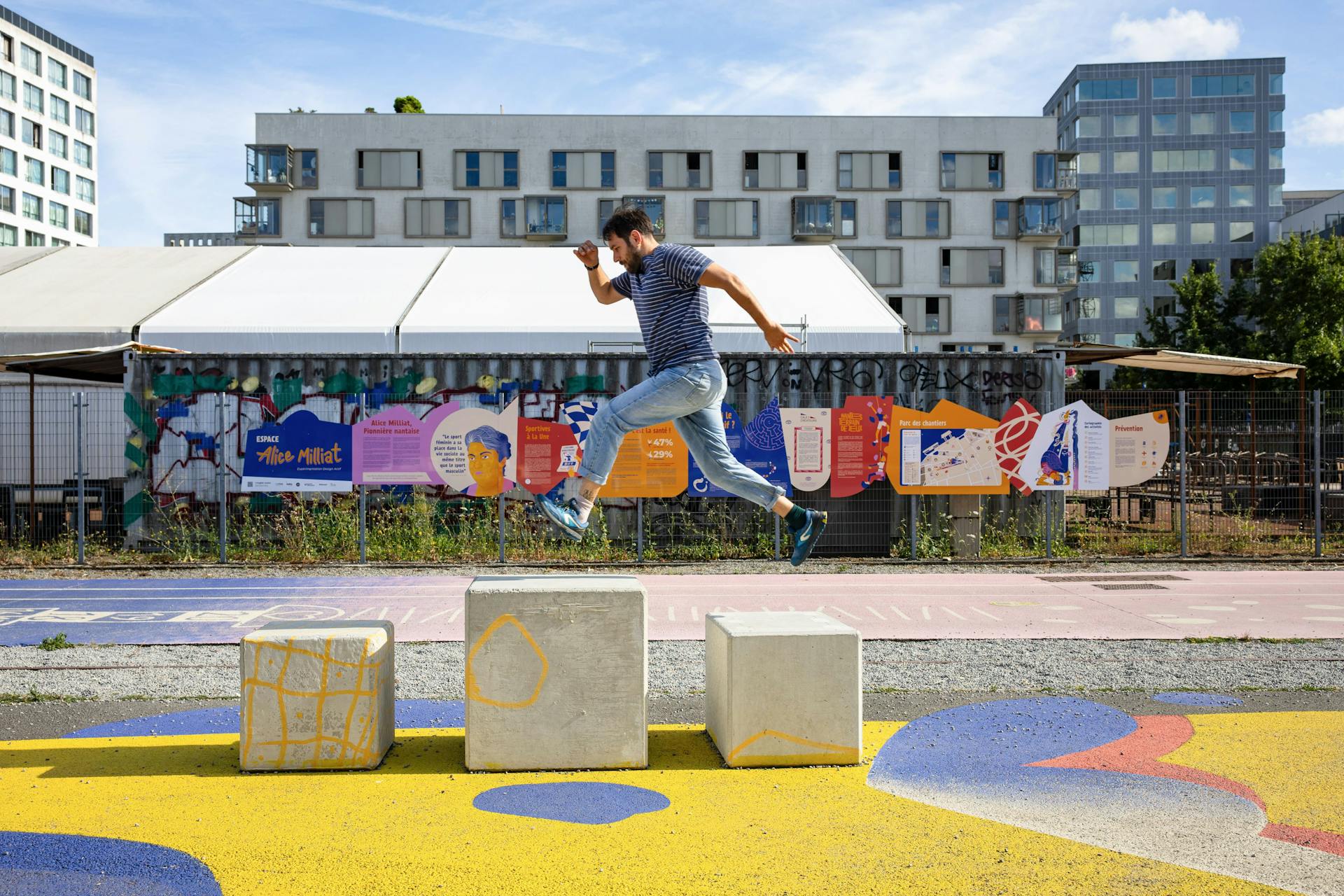 Un homme saute d'un bloc en béton à un autre sur le nouvel espace Alice Milliat de l'Île de nantes, réalisé par l'agence de Design Studio Katra.