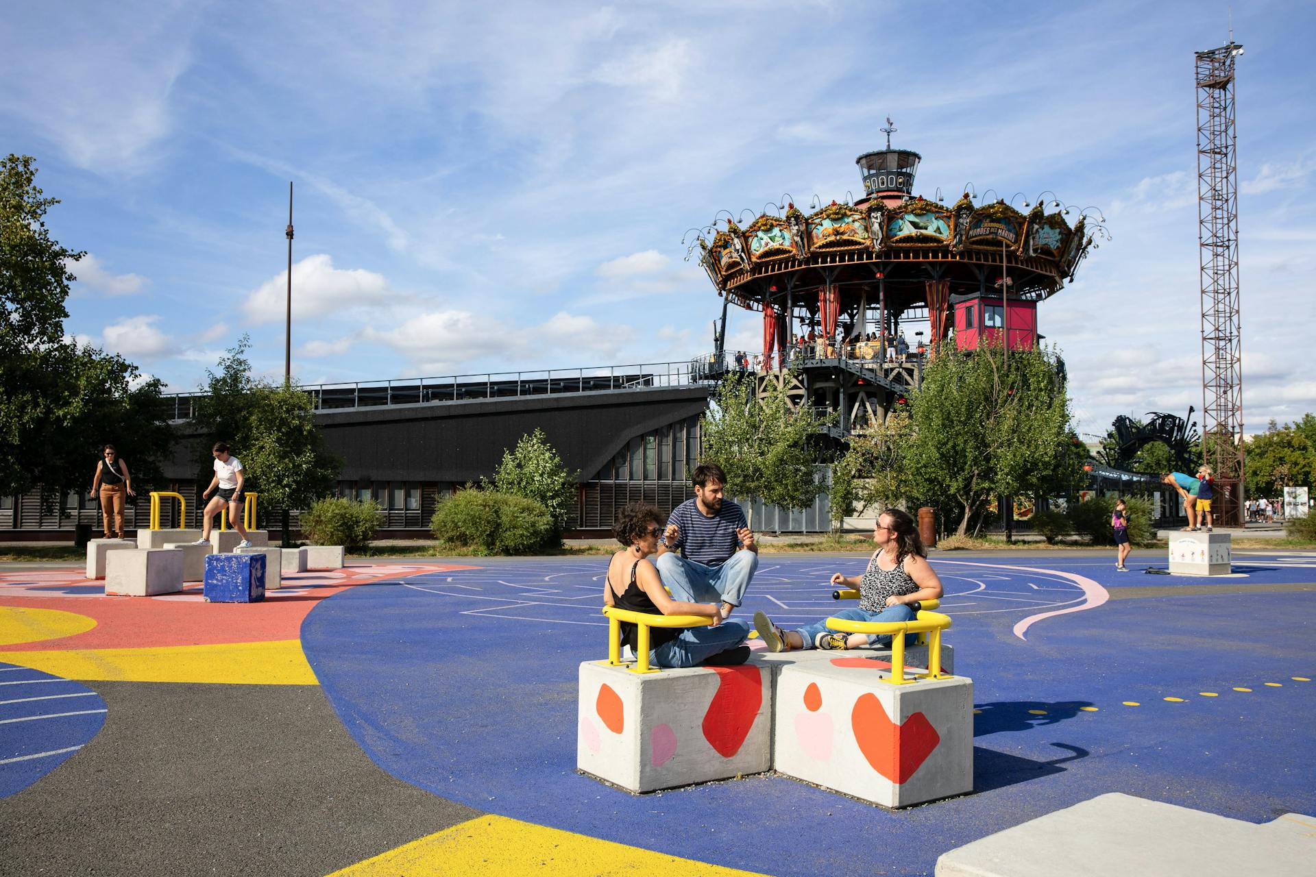 Des passants assis sur des blocs en béton sur le nouvel espace Alice Milliat de l'Île de nantes, réalisé par l'agence de Design Studio Katra.