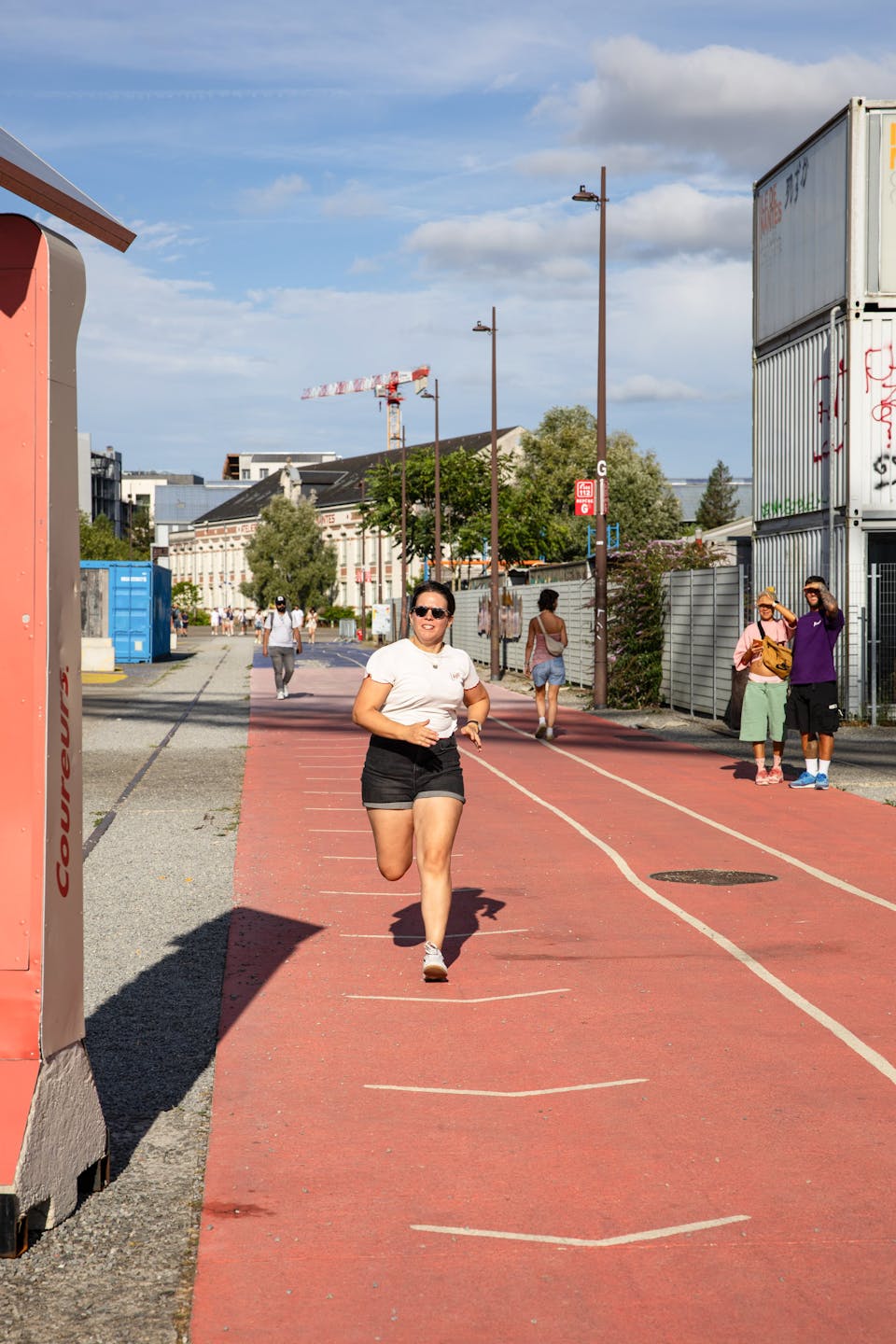 Une personne courant sur la piste d'athlétisme de l'espace Alice Milliat de l'Île de Nantes, sur le Parc des Chantiers.