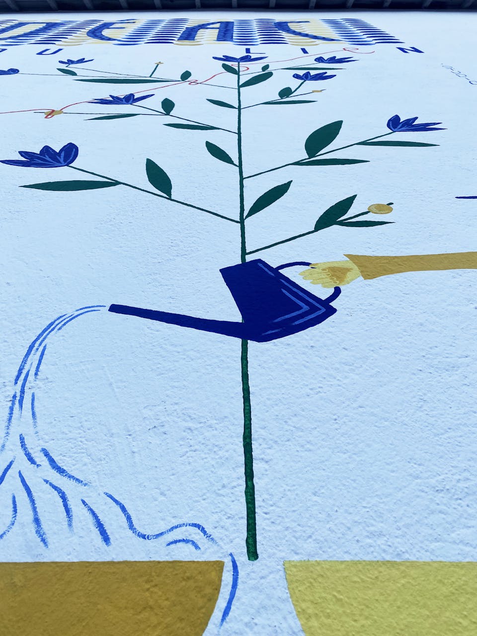 Détails de la fresque murale "Tisser du lien", illustrant une main arrosant une plante.