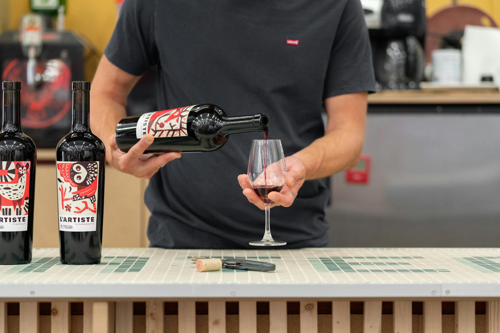 Une personne se servant un verre de la cuvée spéciale du Festival de poupet.