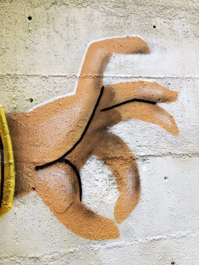 La main d'un des personnages illustrés dans l'oeuvre de street-art nantaise "Une partie de bananes".