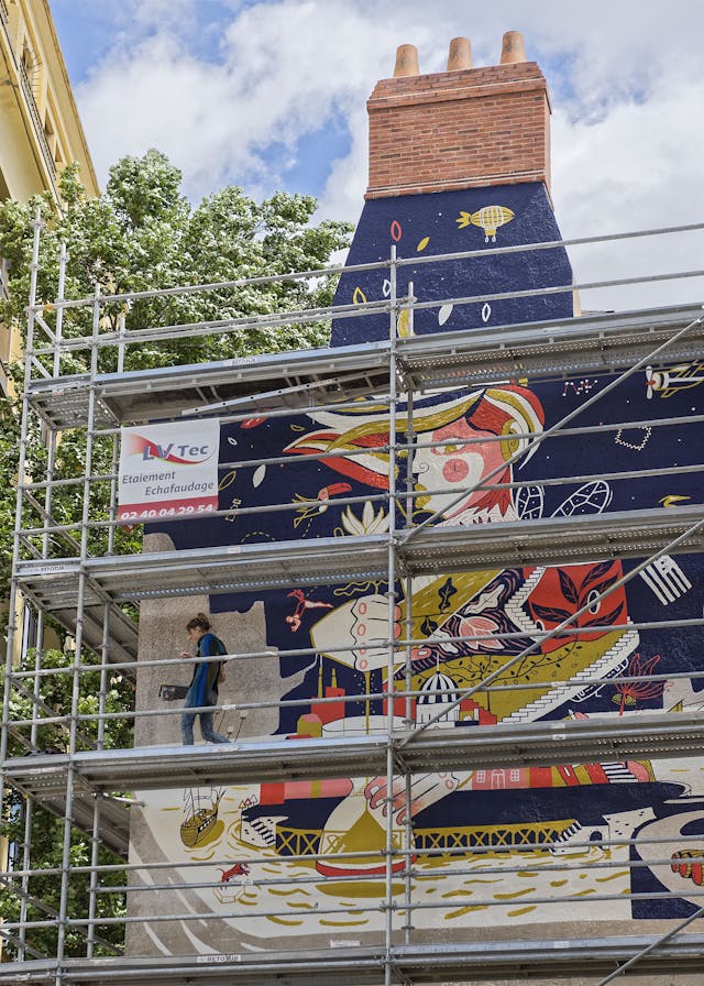Utilisation d'un échafaudage pour la réalisation d'une peinture murale dans les rues de Nantes.