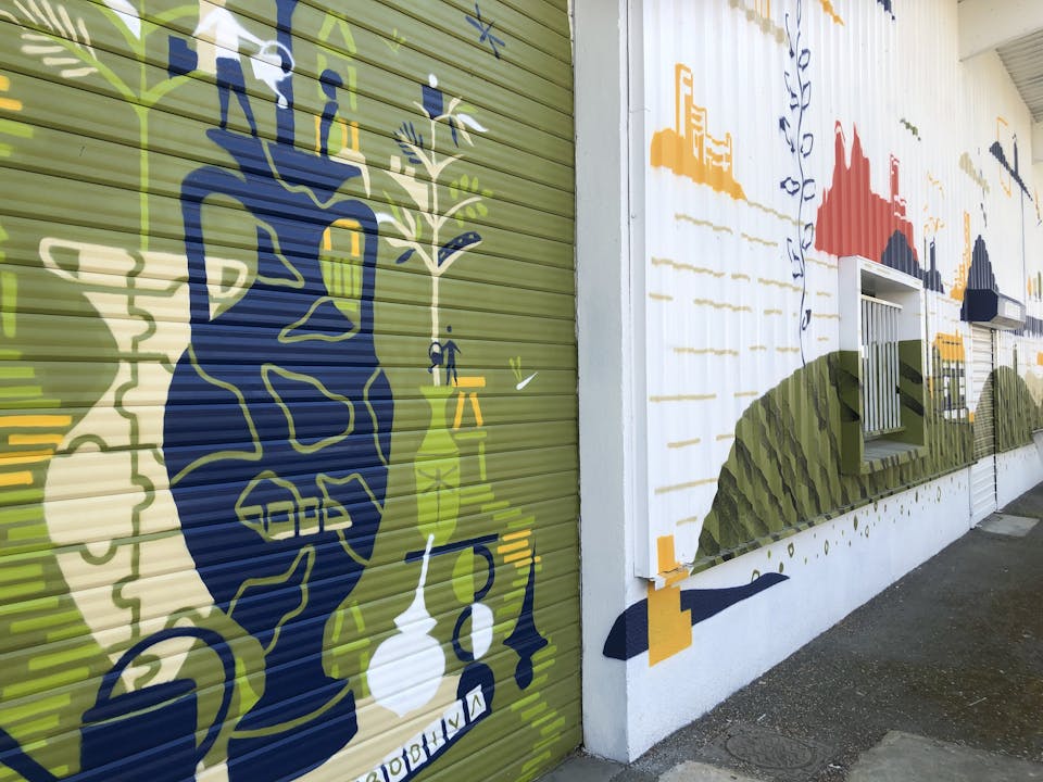 Une grande porte de garage repeinte à l'aide d'une fresque murale street art par l'agence de design graphique Studio Katra.
