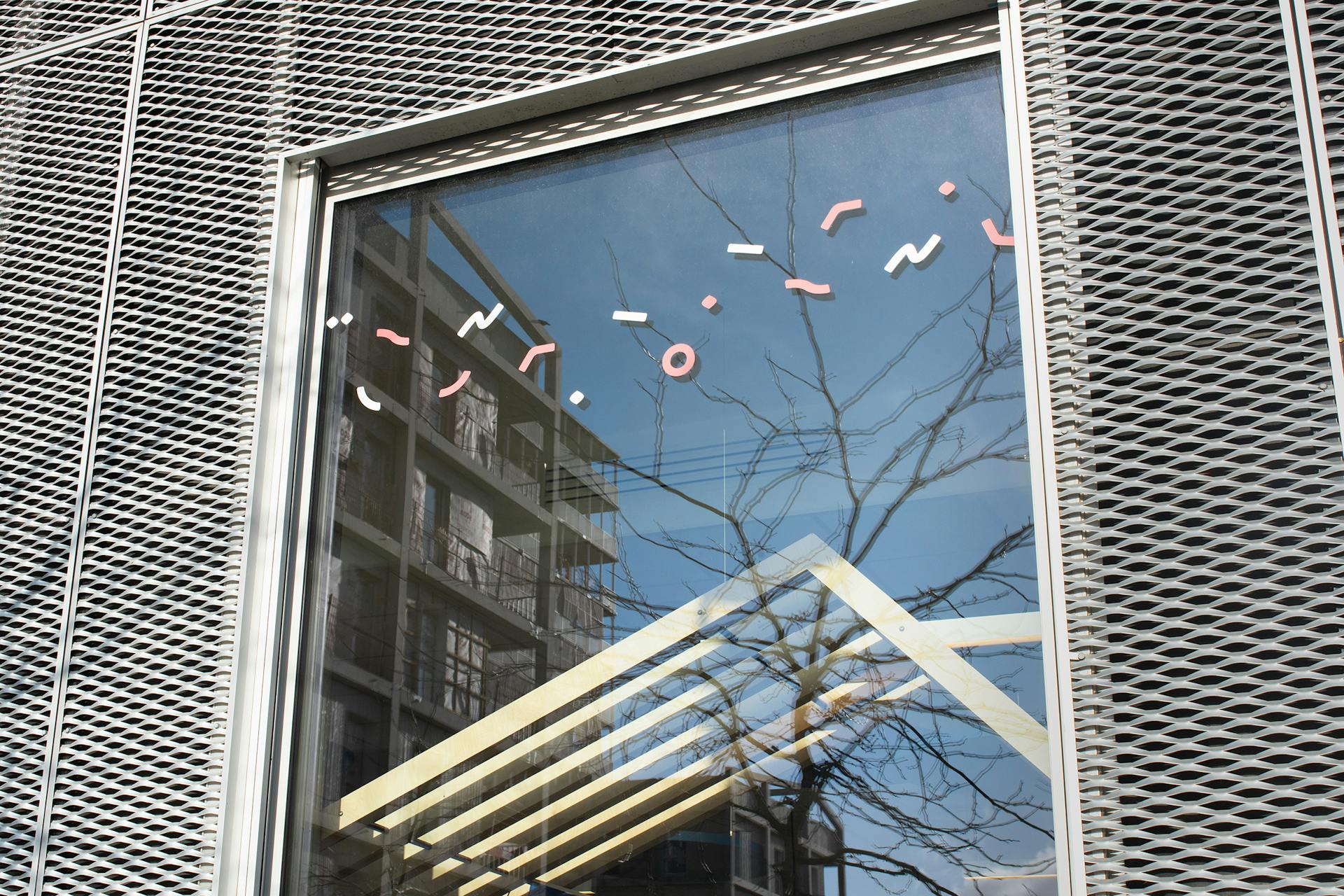 Des stickers issus de la nouvelle charte graphique d'Europa Nantes collés sur la paroi d'une fenêtre.