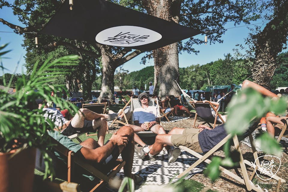 Des festivaliers allongés sur des chaises longues sur une zone de repos du V and B Fest.