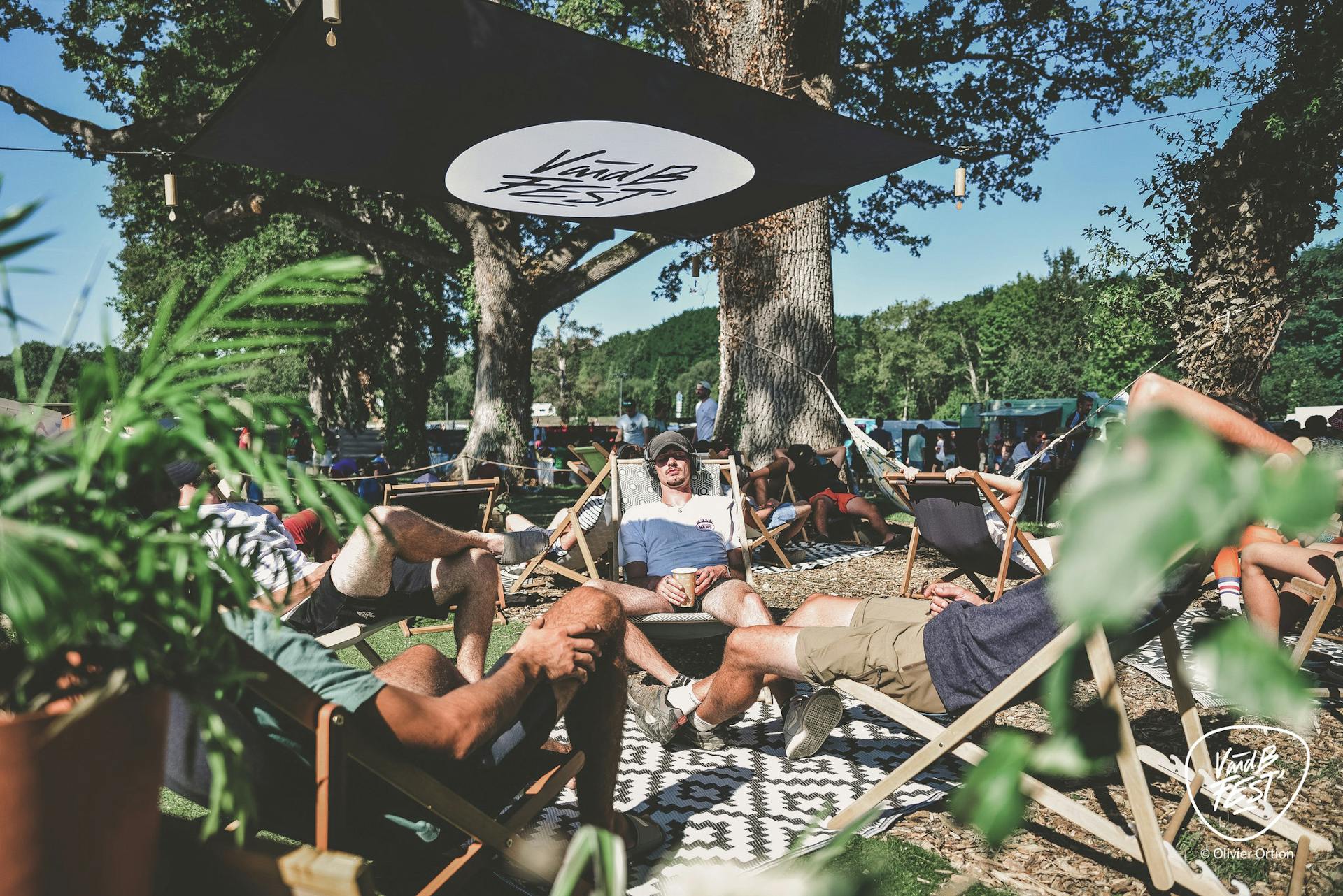 Des festivaliers allongés sur des chaises longues sur une zone de repos du V and B Fest.