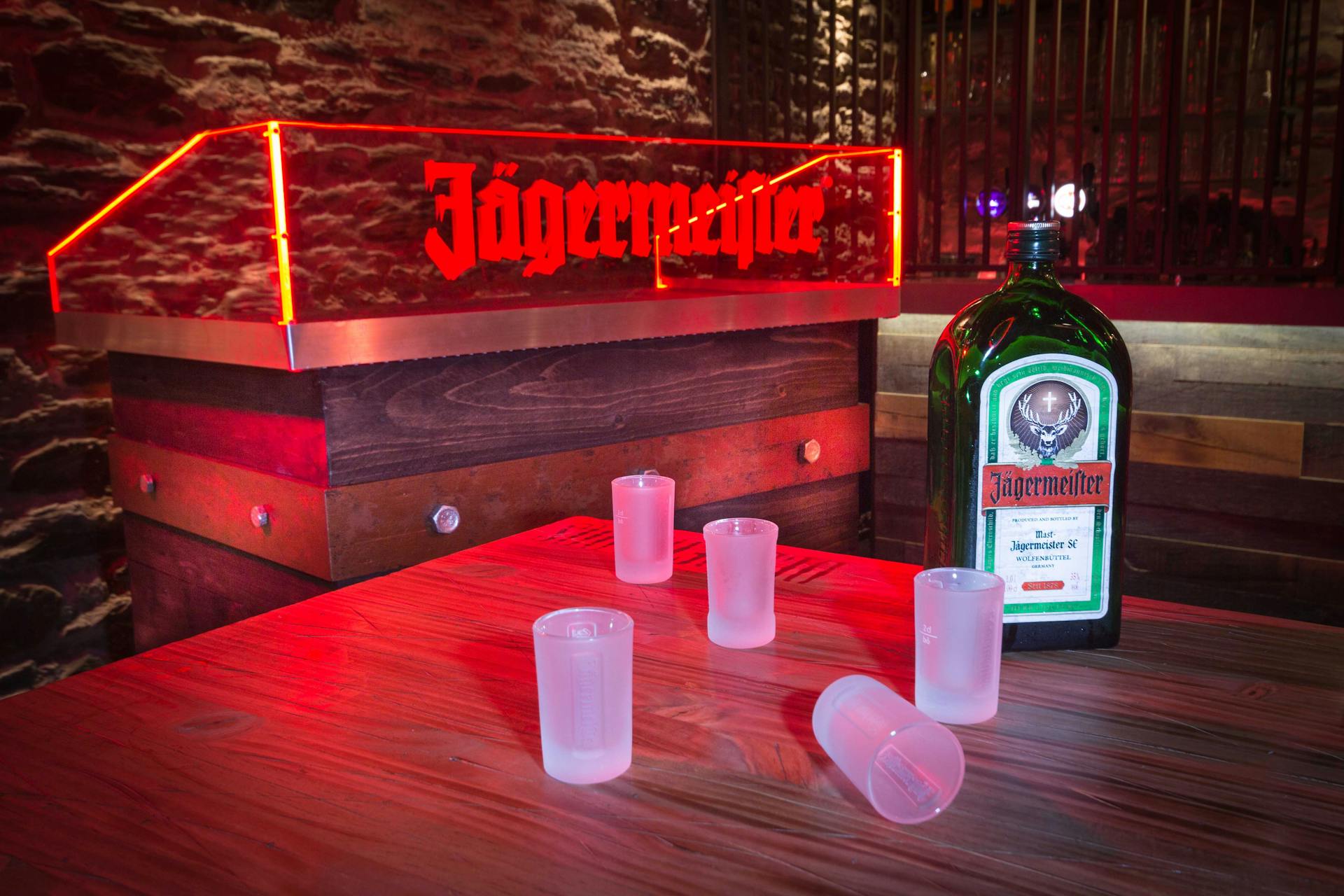 Shooters et bouteille Jägermeister exposés près d'une cabine de DJ pensée par Studio Katra.