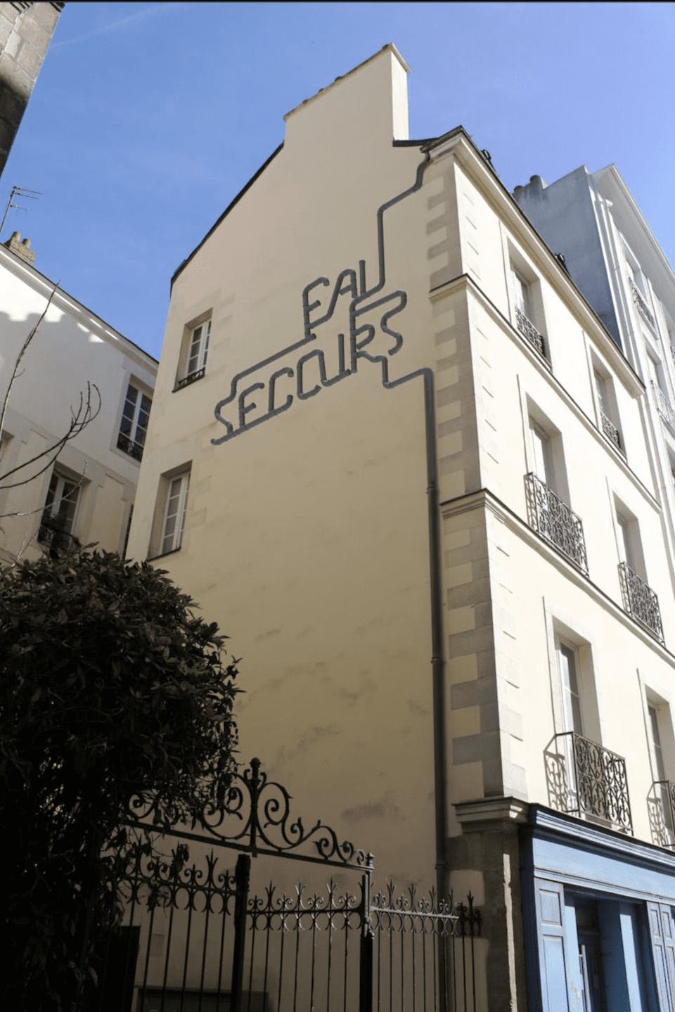 Mise en perspective d'un récupérateur d'eau sur la façade d'un bâtiment.