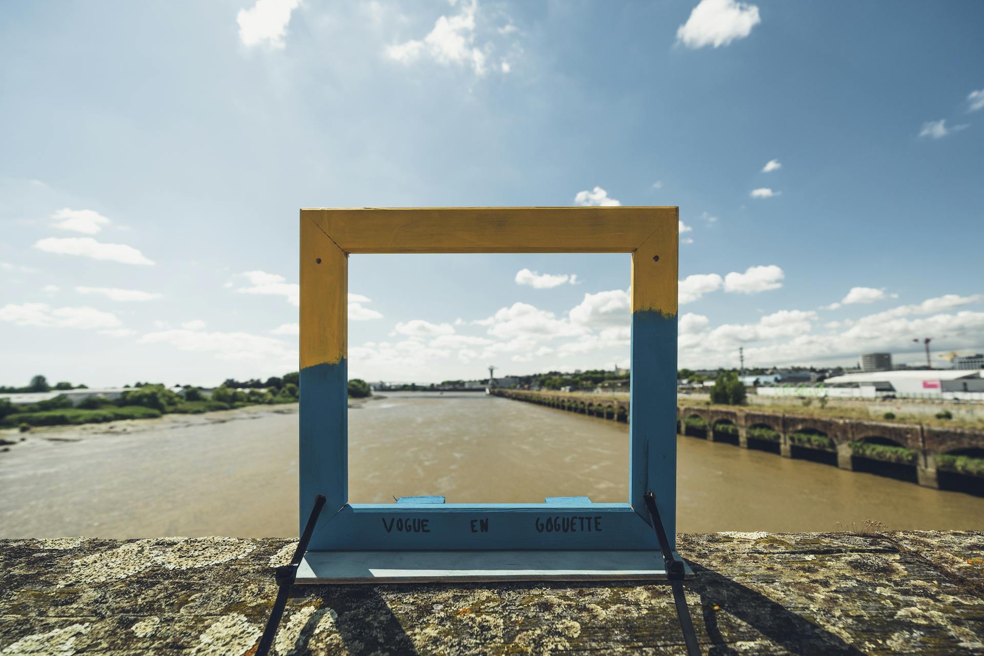Installation éphémère de Transfert. Un cadre en bois positionner face à la Loire, offrant un paysage de la ville de Nantes.