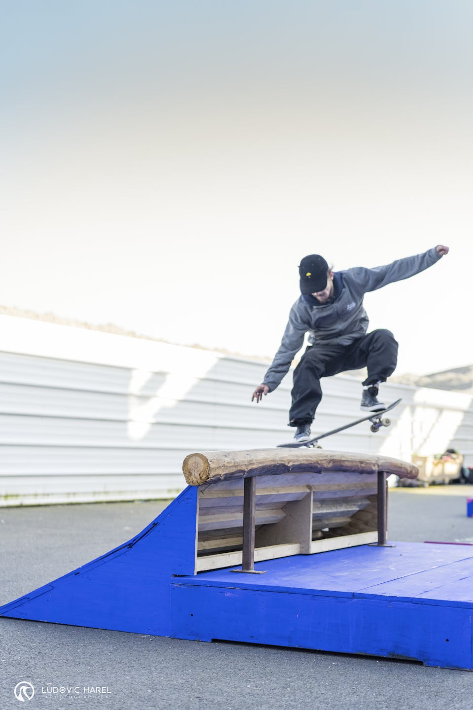 Skateur s'élançant sur une rampe d'un module en bois.