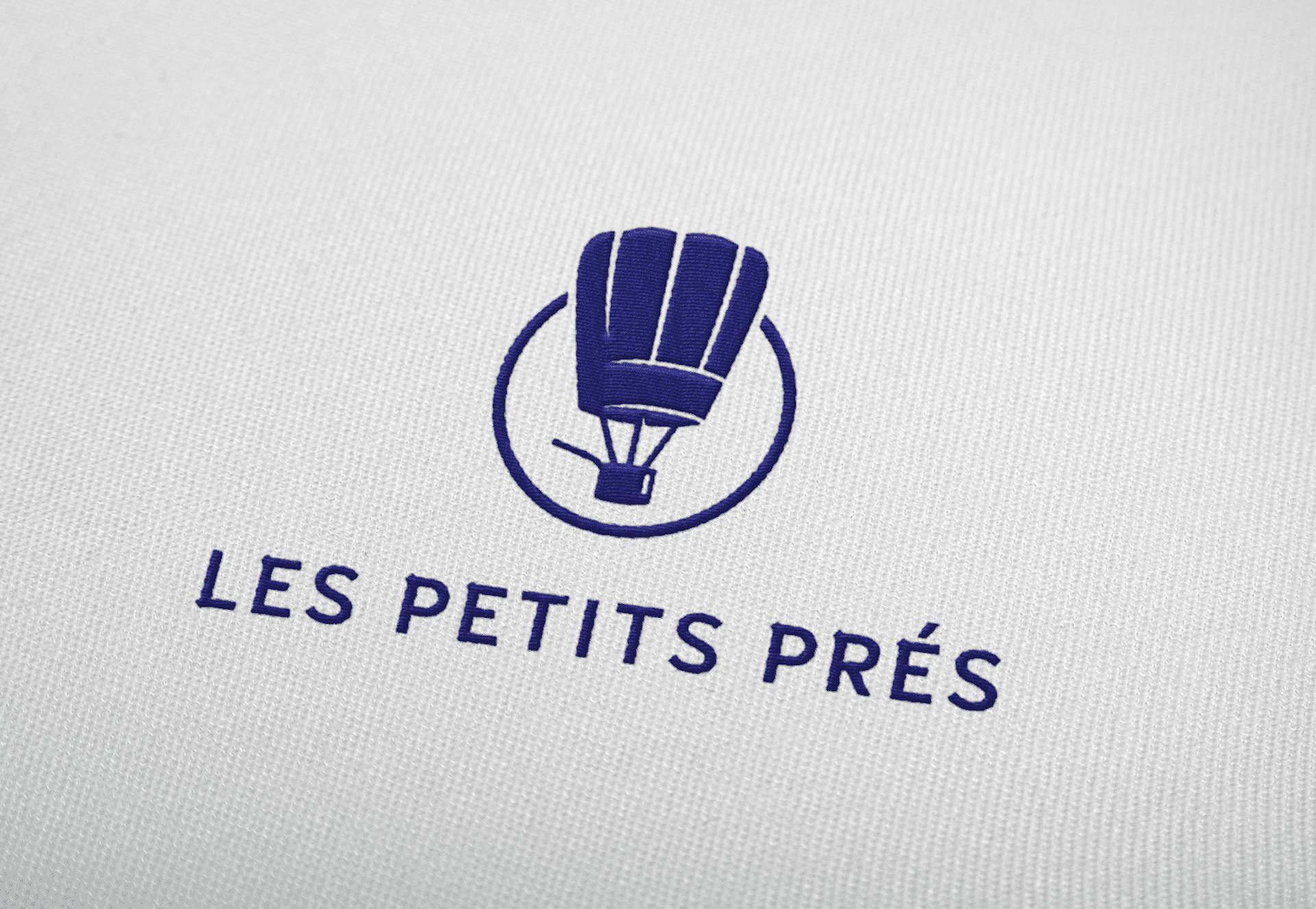 Mockup du nouveau logo du restaurant "Les Petits Prés" sur tissu, réalisé par l'agence de design graphique Studio Katra