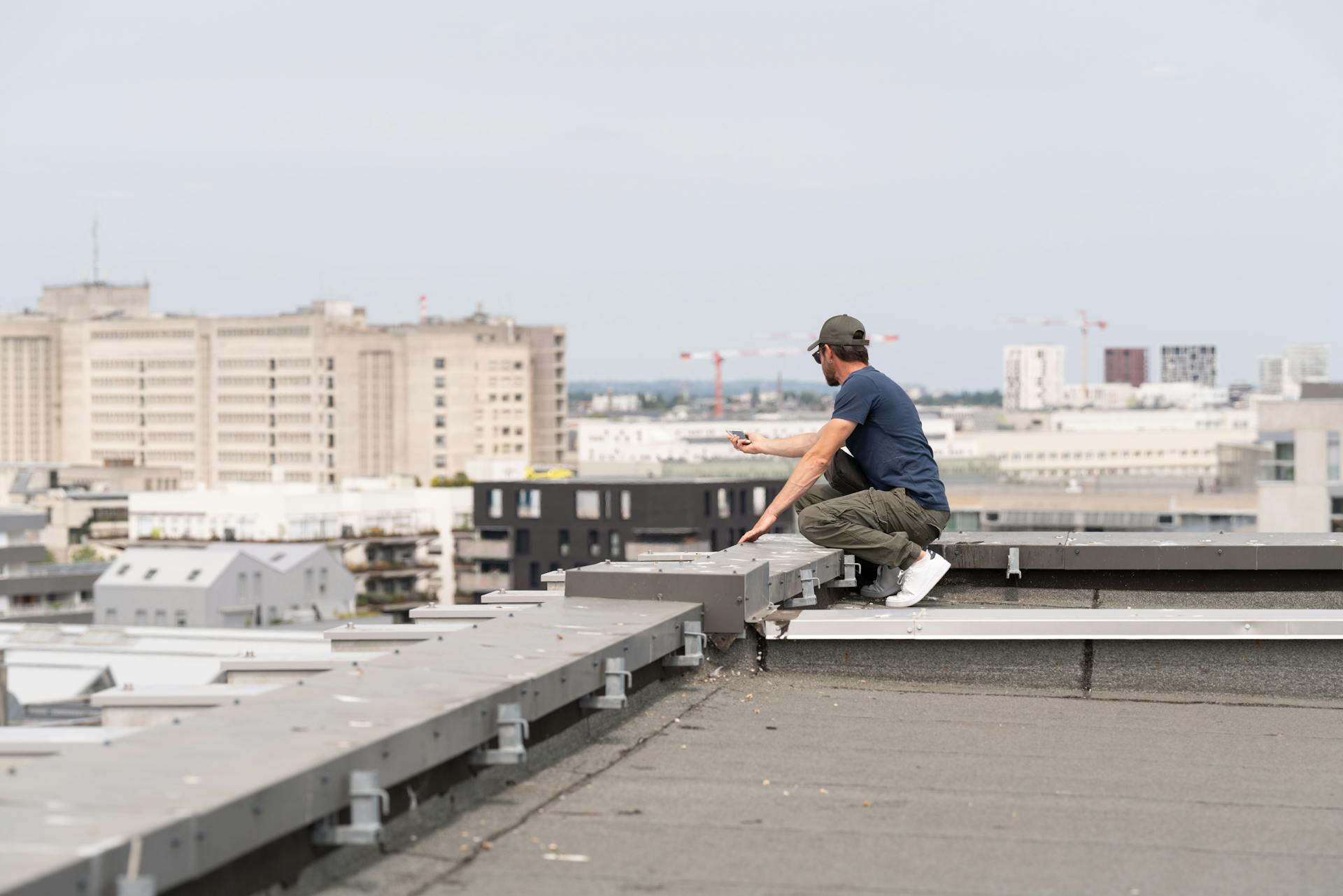 Camille Pansard, designer graphique chez Studio Katra, tente de ne pas tomber lors d'une prise de photo depuis le haut d'un bâtiment.