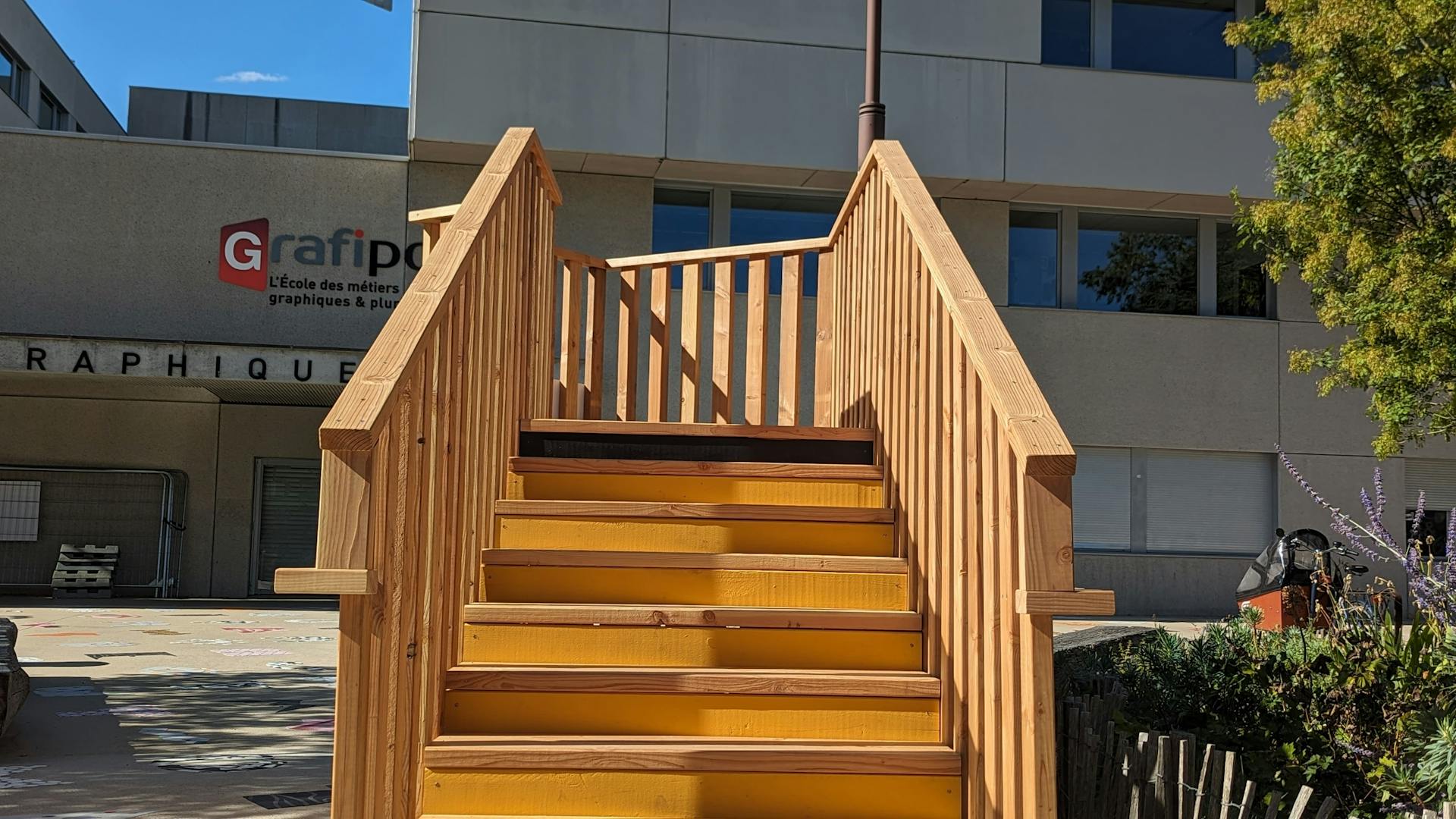 Un promontoire en bois réalisé par l'agence de design Studio Katra, installé sur le parvis de l'école la Joliverie dans le cadre du projet "le Champ des Signes".