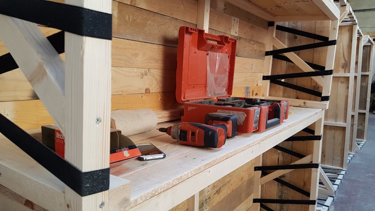 Outils entreposés sur du mobilier en bois conçu pour le design d'espace d'un festival nantais.