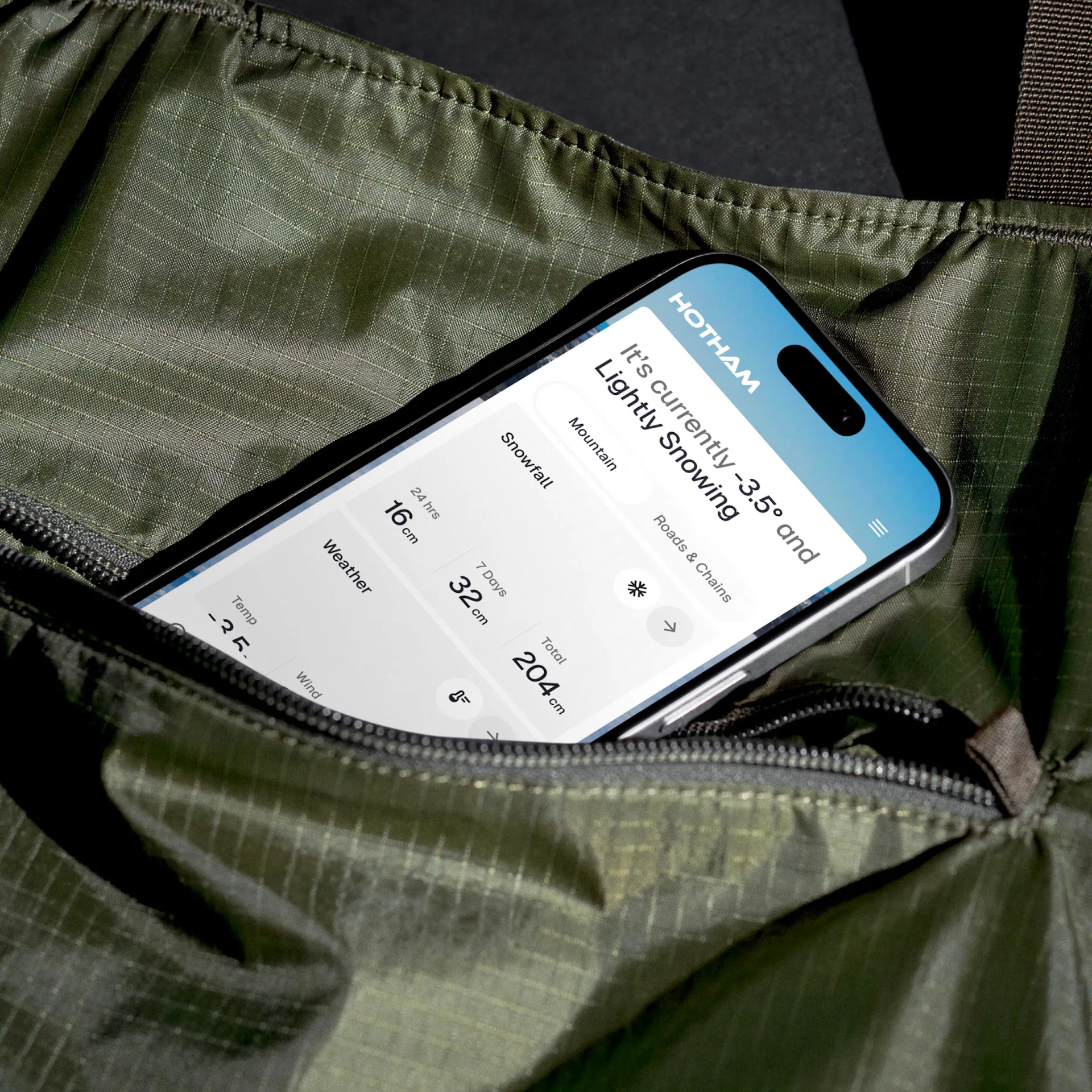 Hotham website on a mobile phone resting in the pocket of a water proof jacket