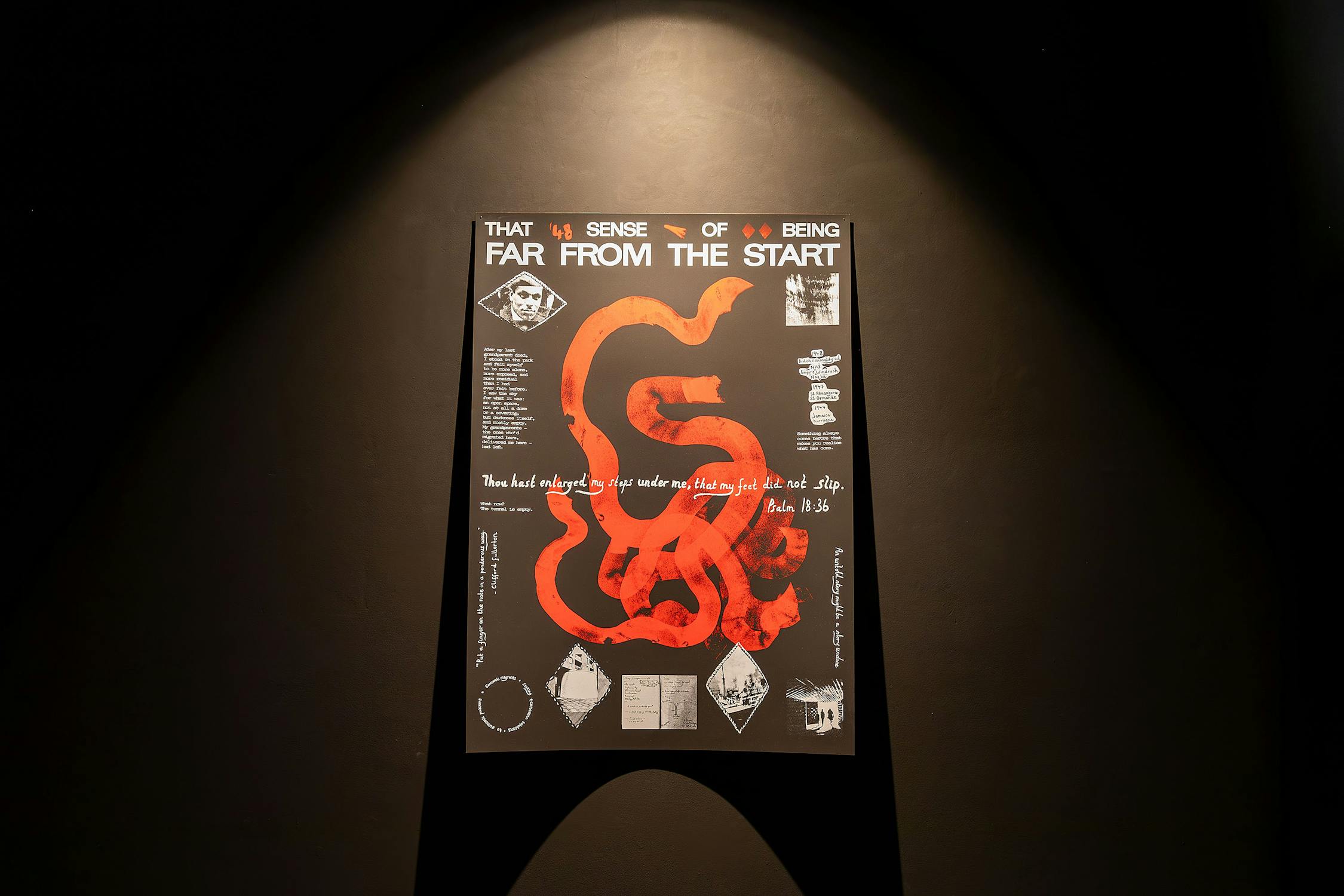a photograph of a screenpainted poster against mounted on a black wall. The poster is downlit and shadowy. The poster has a swirling red line in the centre, and smaller screenpainted images in white around the edge.