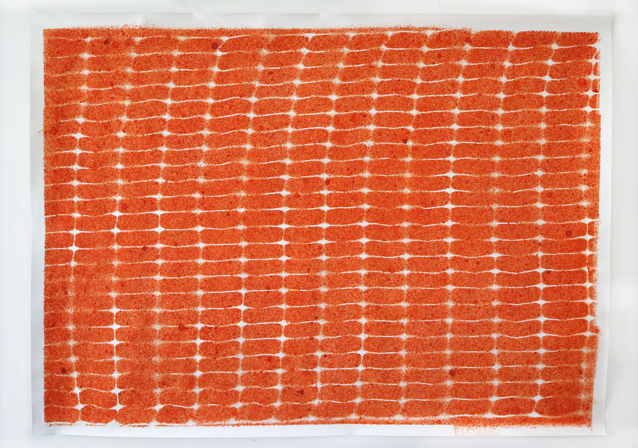 Abstract artwork on white paper featuring a dense grid of orange-red rectangular shapes separated by thin white lines, resembling a brick pattern. Texture appears granular or sandy. Small red dots scattered throughout.