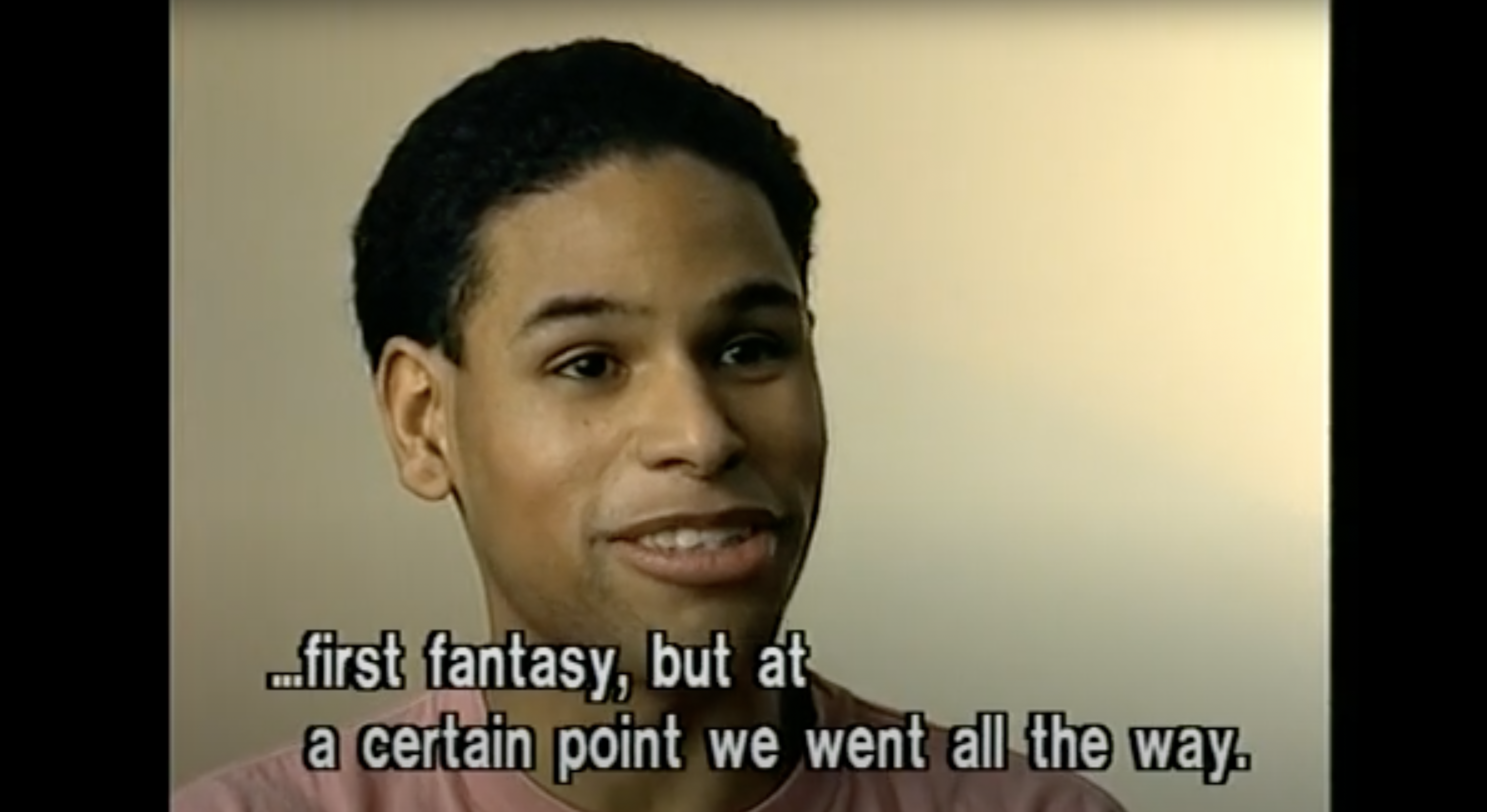 A person with short dark hair is speaking. The text on the image reads, "...first fantasy, but at a certain point we went all the way." The background is plain and light-colored.