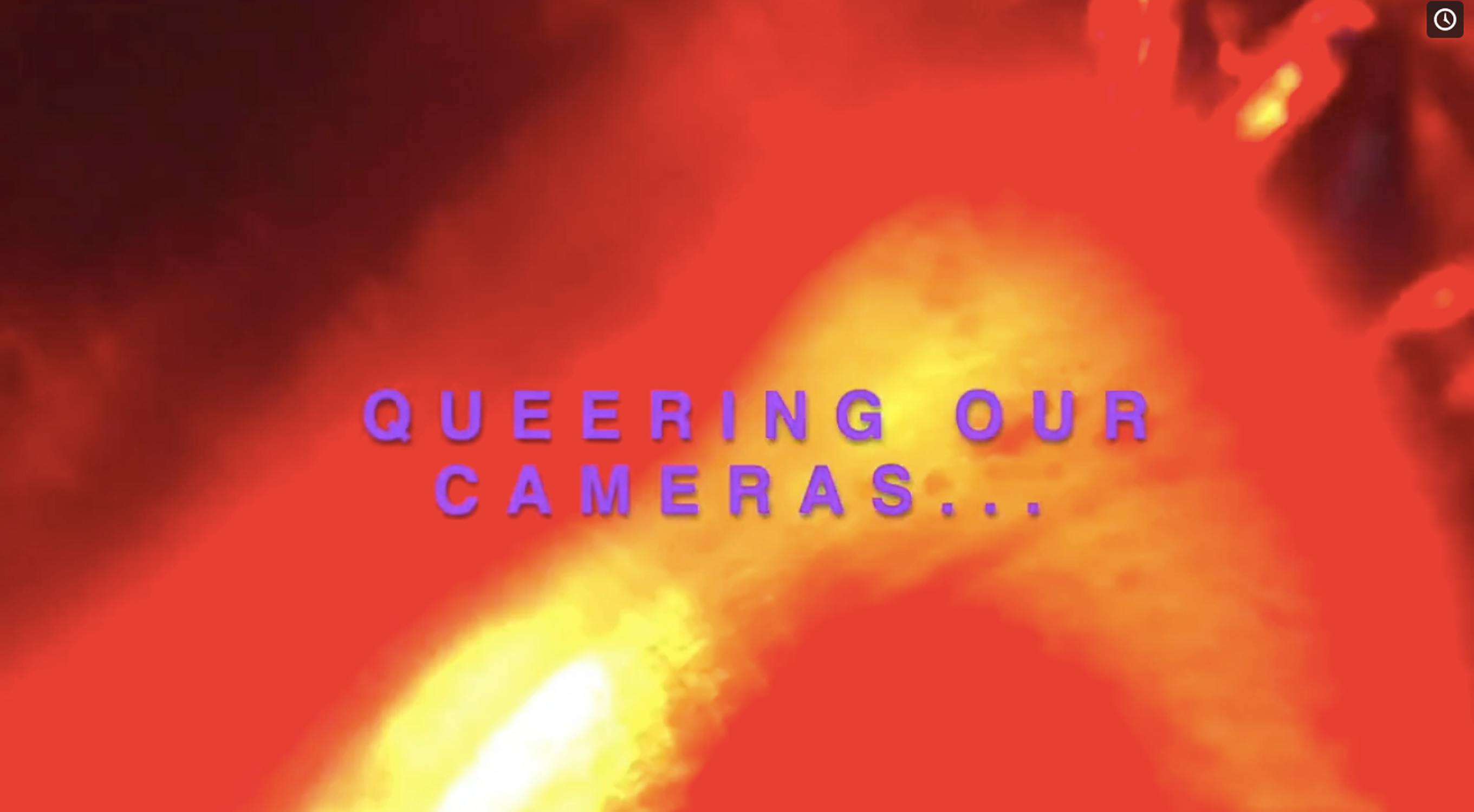 A vivid red and orange abstract background with the text "QUEERING OUR CAMERAS..." in bold, blue letters in the centre.