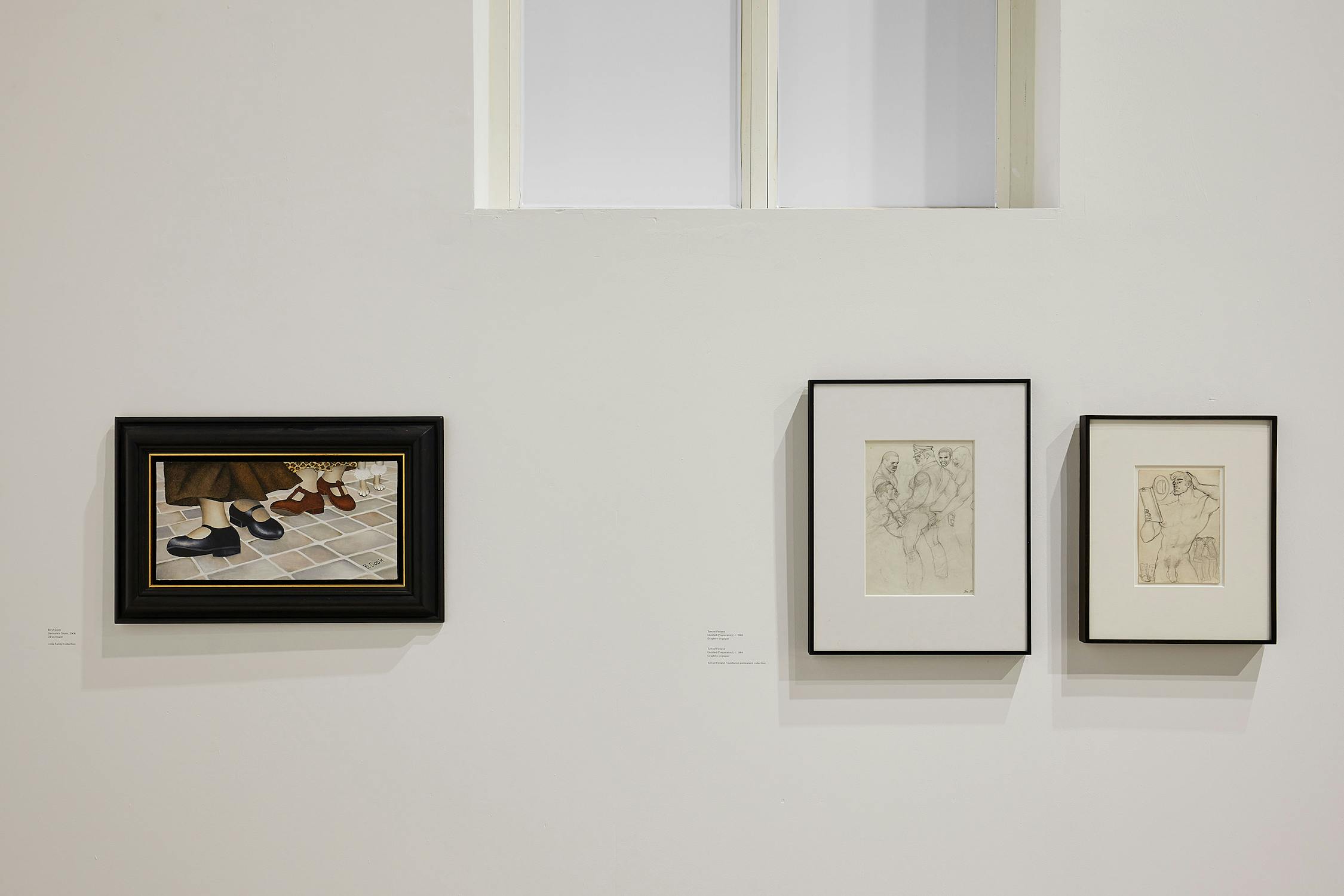 a painting of women's shoes by beryl cook hung beside two framed preliminary sketches of men engaged in sexual acts by Tom of Finland