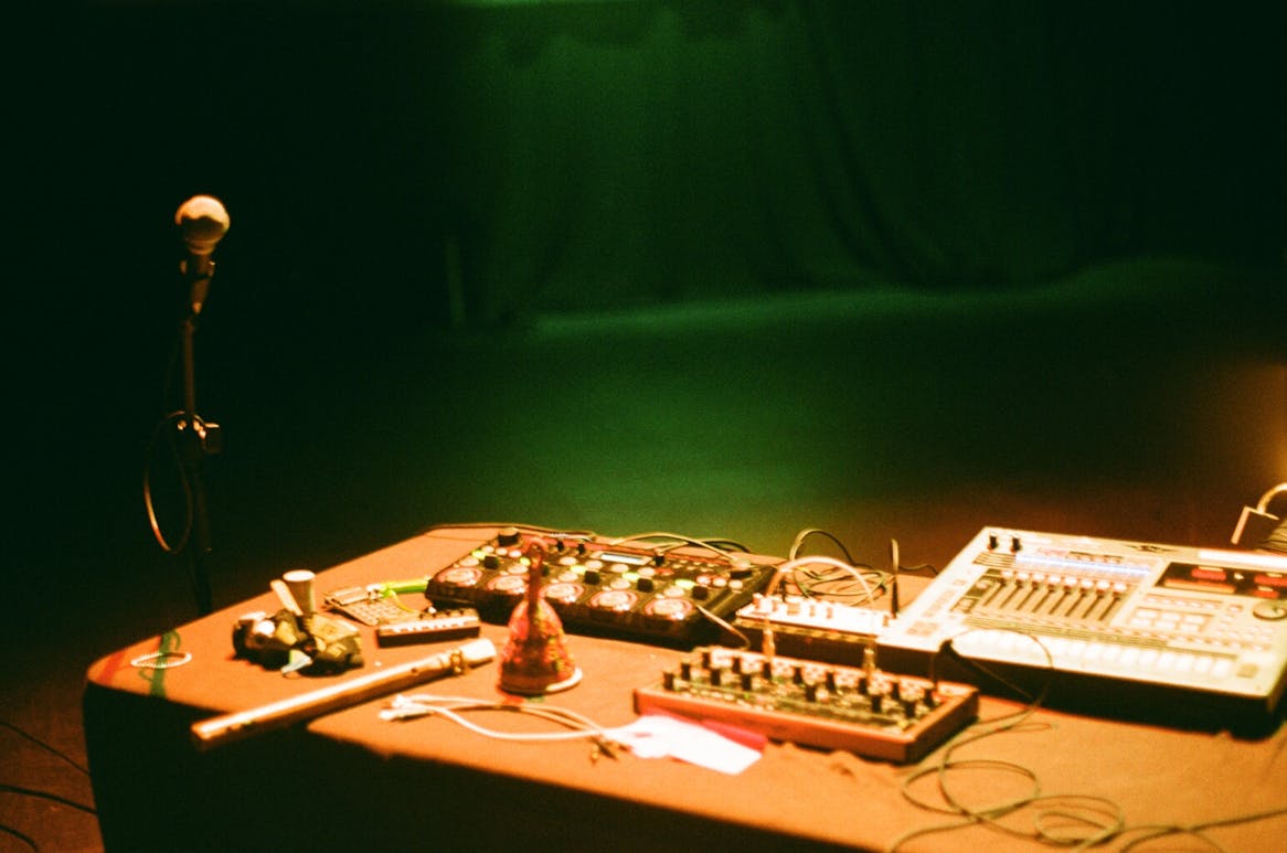 A blurred image of a microphone and audio mixing equipment on a table 