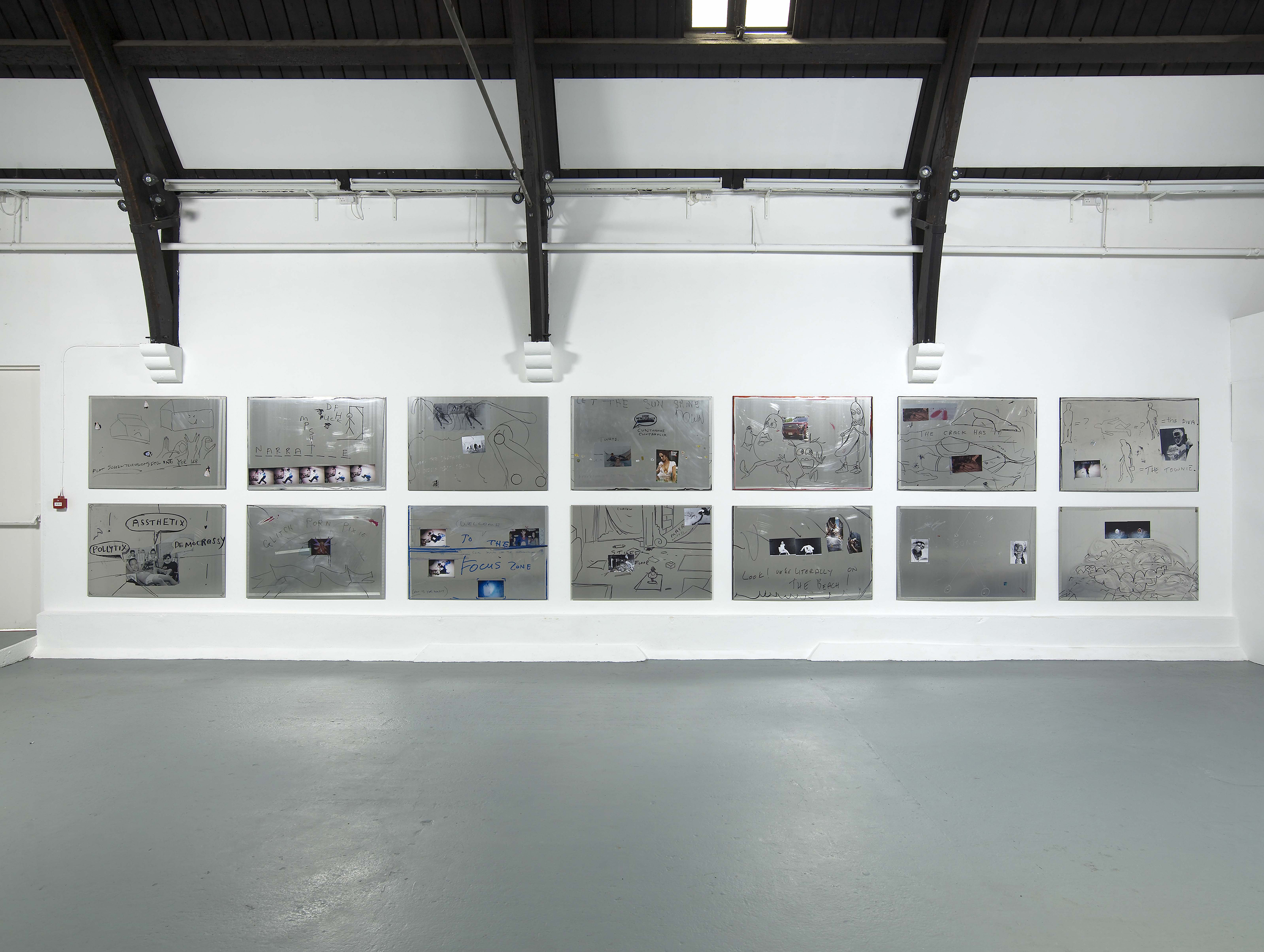 Aluminium tiles with collage, text and drawings on them, installed on to a white gallery wall