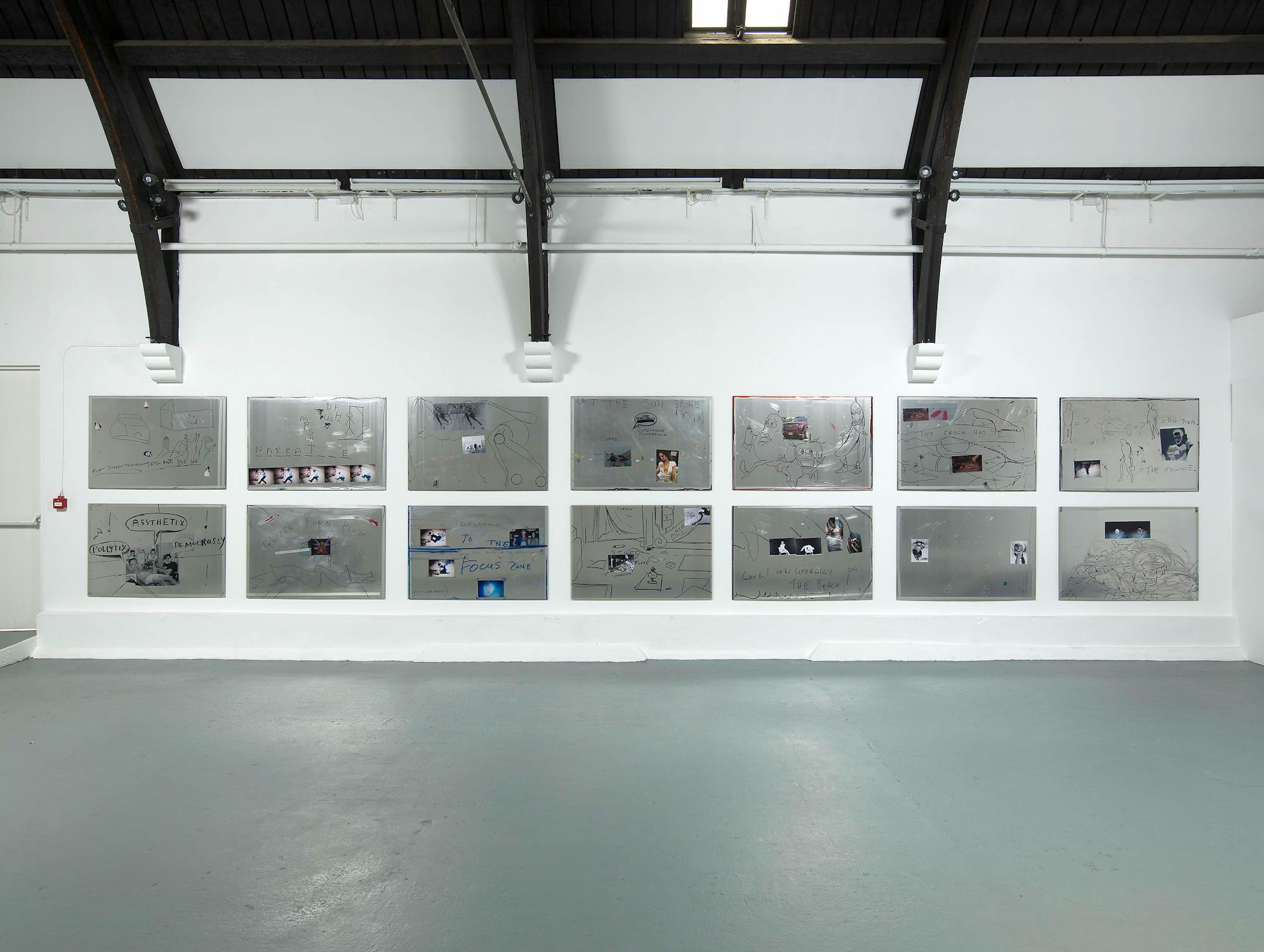 Aluminium tiles with collage, text and drawings on them, installed on to a white gallery wall