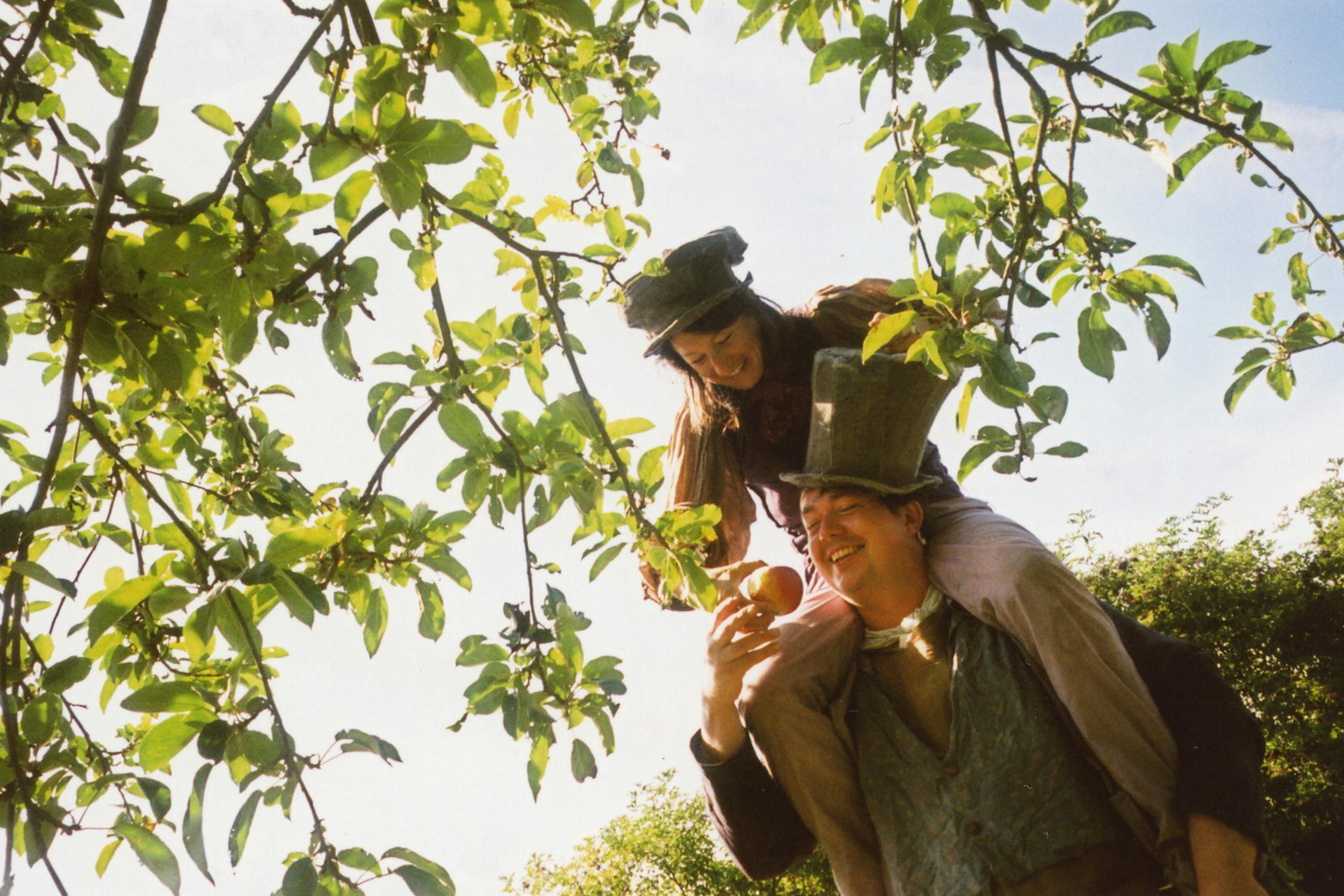 Film photograph of someone on someones shoulders picking apples