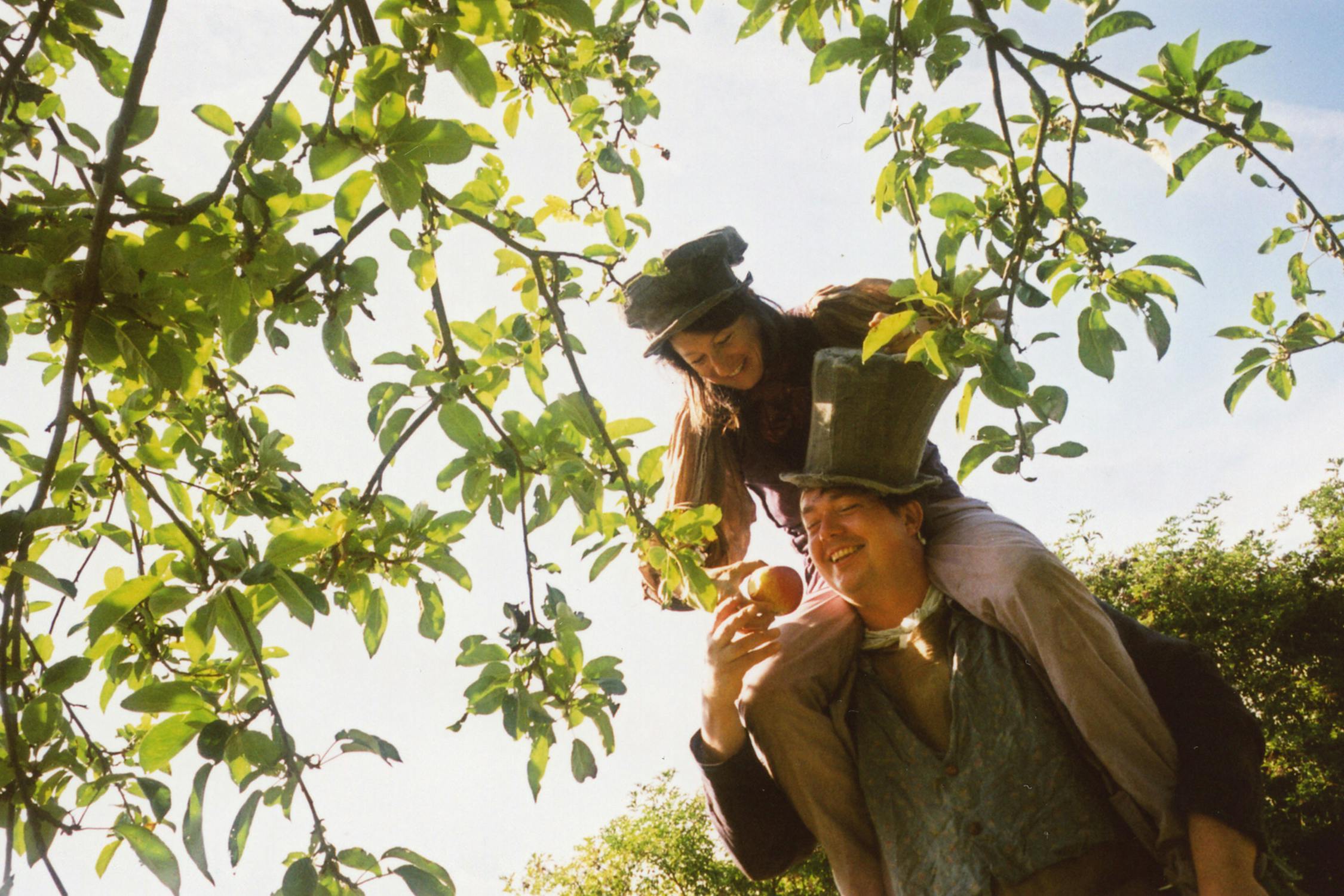 Film photograph of someone on someones shoulders picking apples 