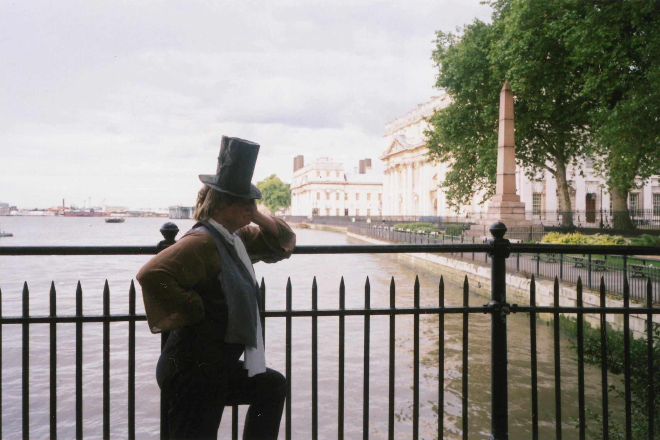 film photograph of someone leaning on a bridge on the river thames