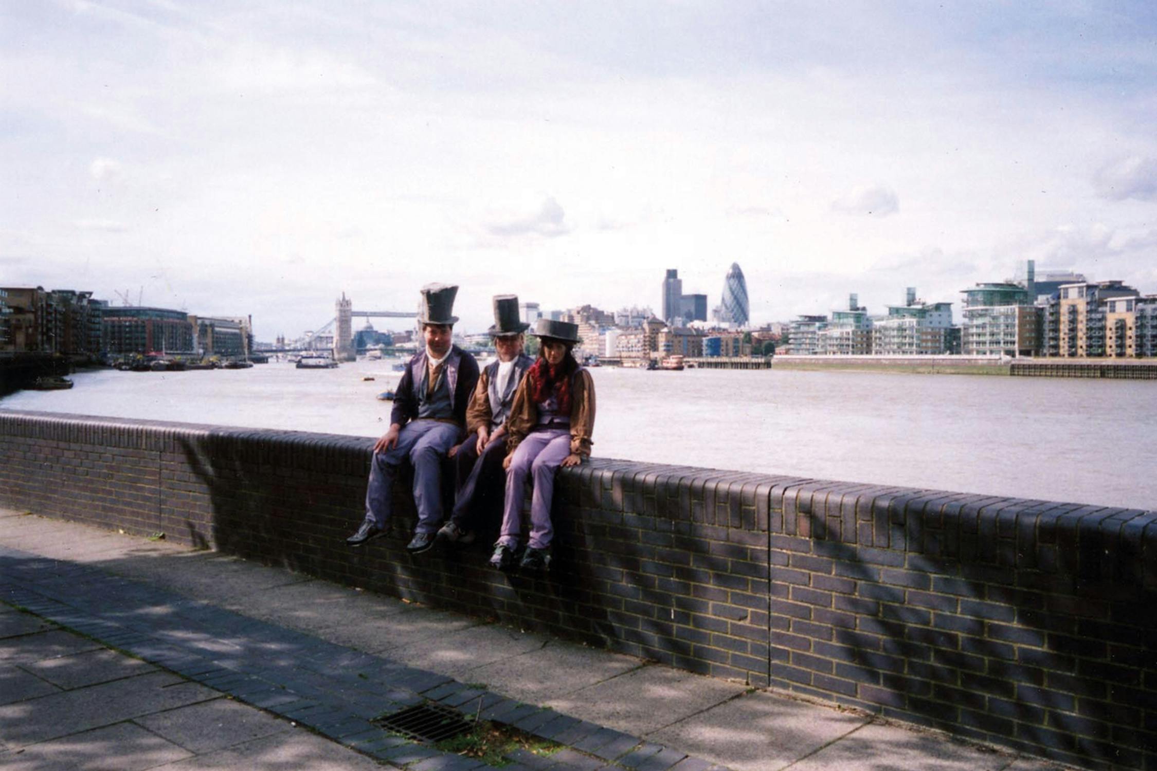 Film photograph of three people sitting on the wall along the river Thames