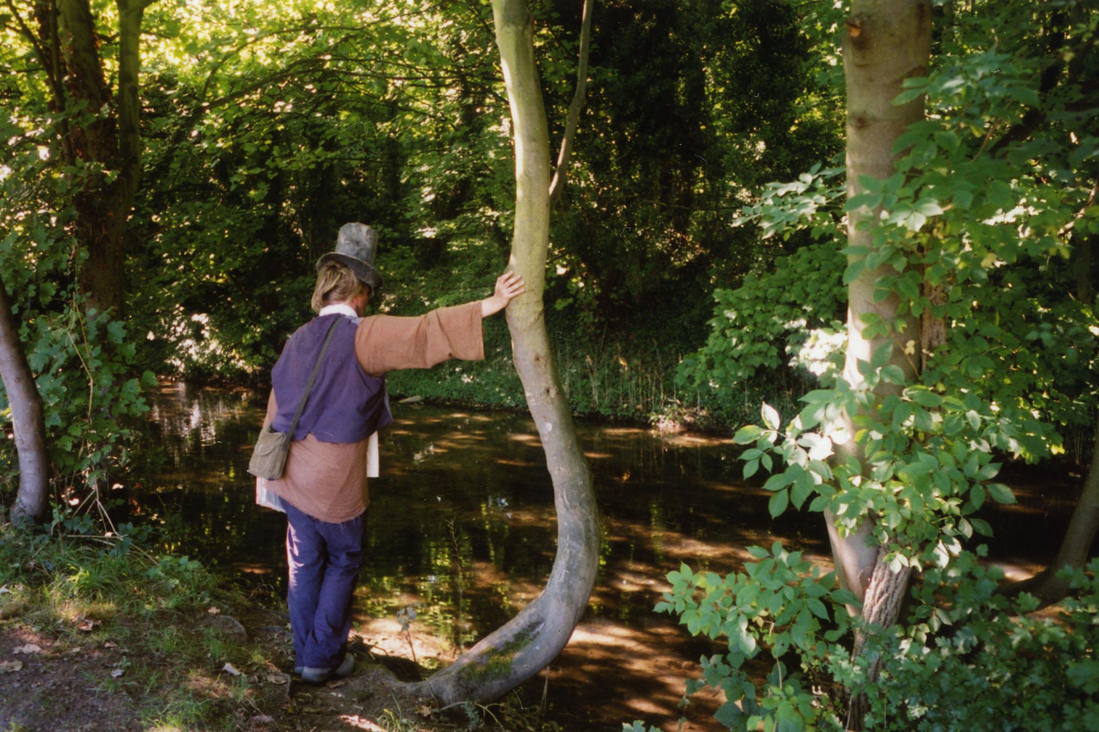 Film photograph of someone leaning on a tree looking at a river