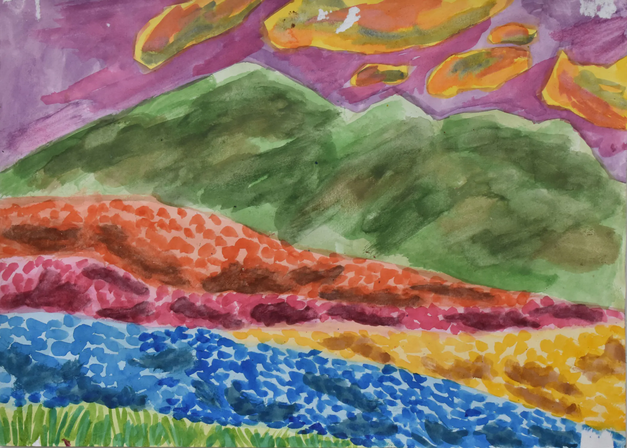 A vibrant watercolour landscape by Donald Fasanya, showing green mountains under a purple sky with orange clouds. The foreground has colourful hills with patches of red, yellow, blue, and green, suggesting fields of wildflowers or foliage. The style is bold and impressionistic.