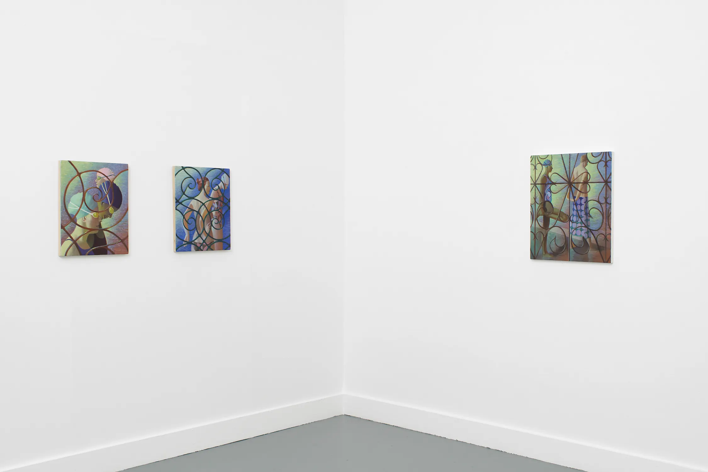 Three colourful paintings by Benjamin Senior with looping circular patterns hang on the white walls of a minimalist gallery corner. Two are on the left wall, spaced evenly, and one larger piece is on the right wall. The floor is grey, and the space is empty.