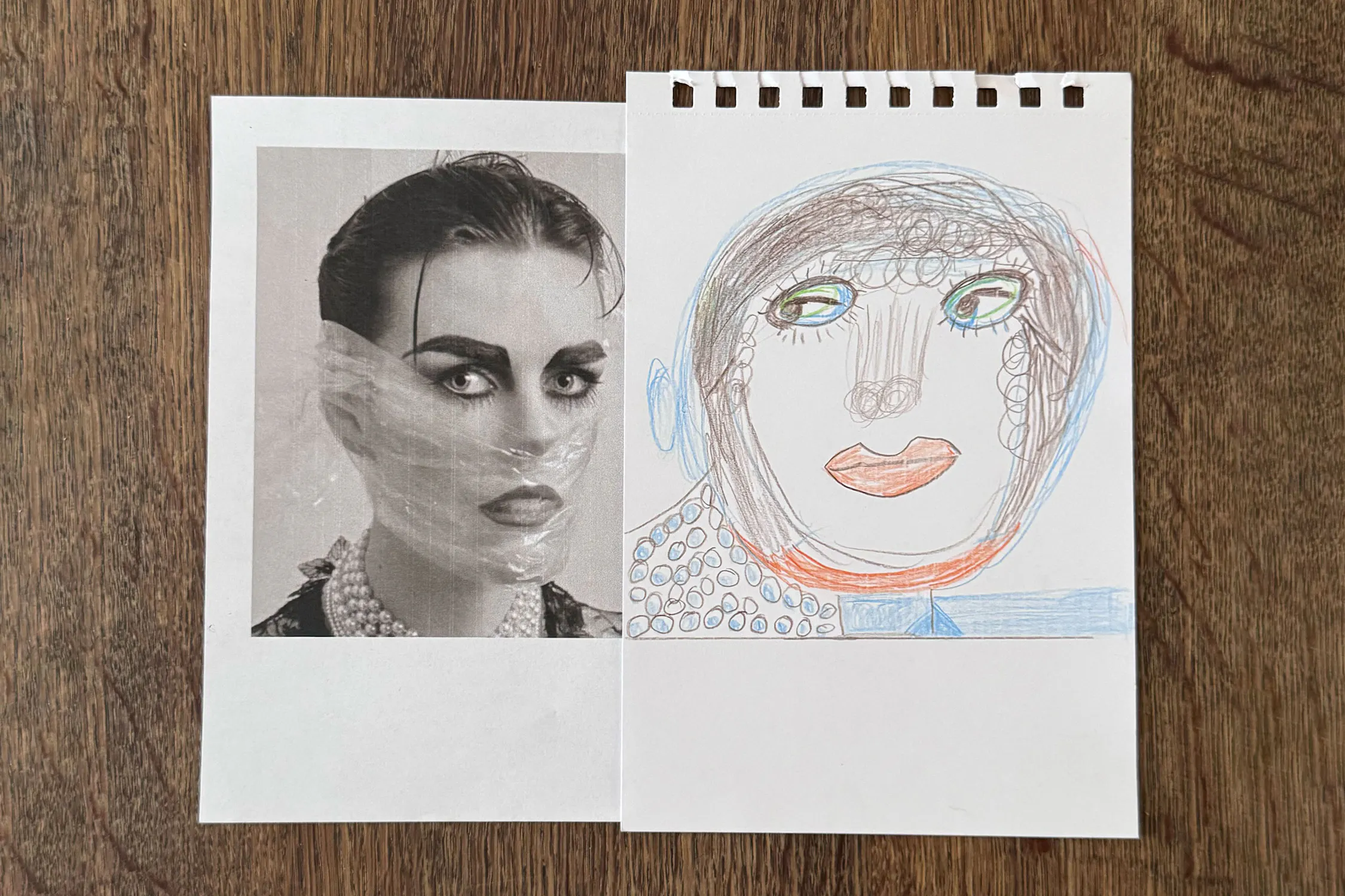 A black-and-white photo of artist Linder Sterling is placed beside Christine Hazell's colourful drawing of a similar face on white paper. The drawing mimics the photo’s features with exaggerated shapes, bold lines, and added necklace detail, both on a wooden surface.