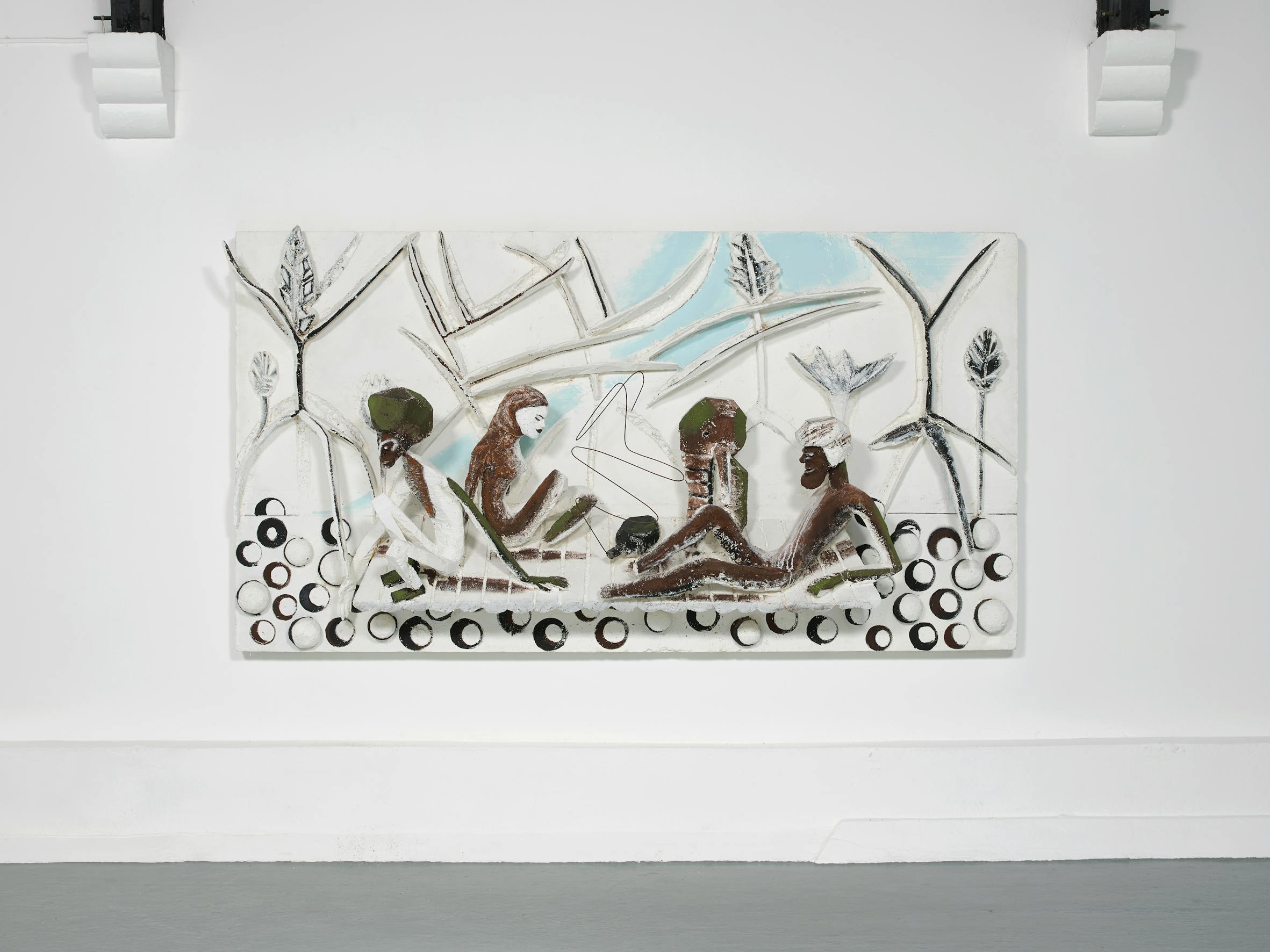 A mixed-media artwork shows four abstract figures with brown and white tones sitting in a circle. They face each other, surrounded by circular and angular shapes. The pale background features plant-like patterns and a light blue sky.