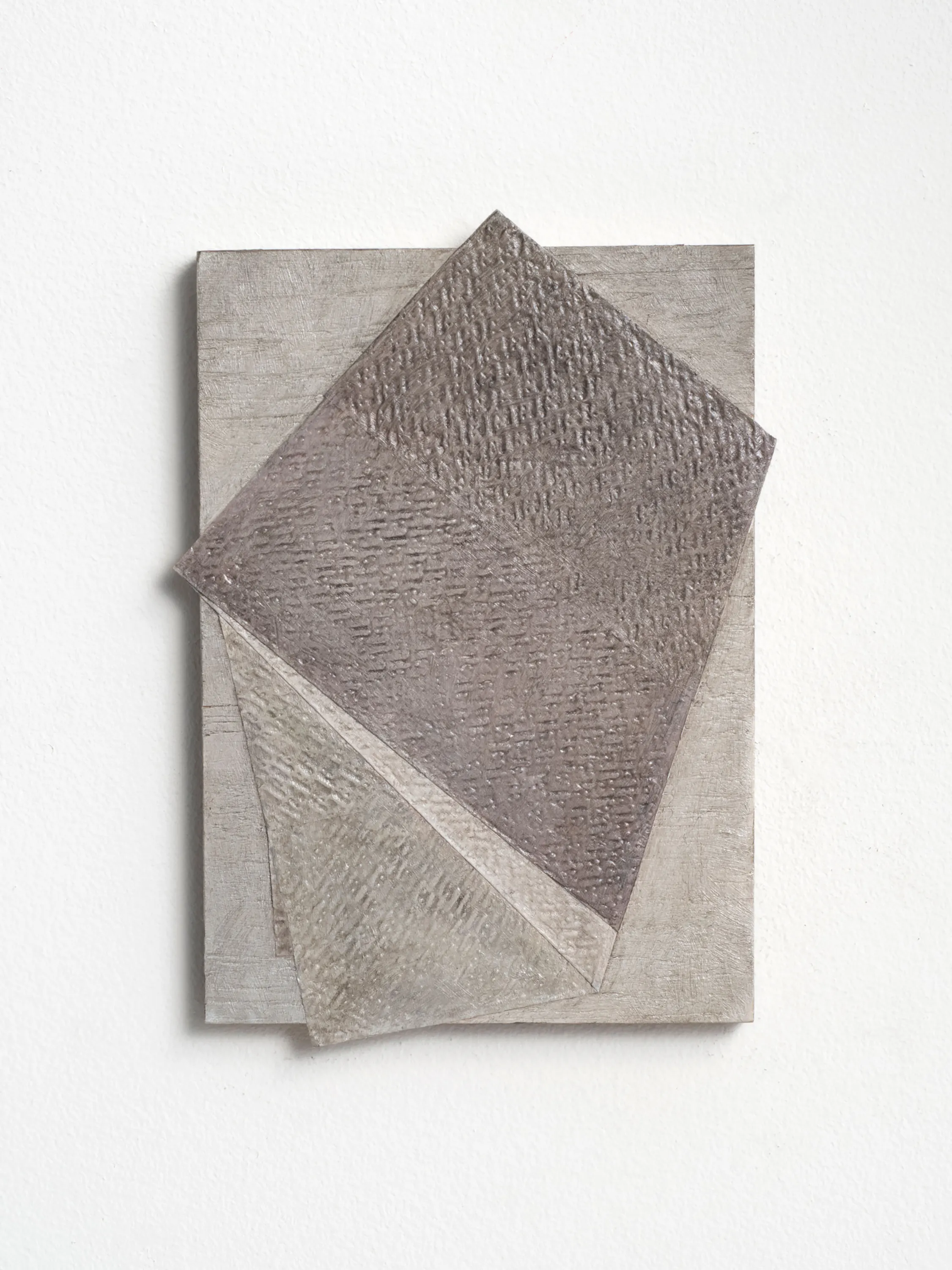 A textured, abstract artwork with three overlapping, raised quadrilateral shapes in muted beige and grey tones, arranged on a rectangular canvas. The layered surfaces feature subtle linear patterns, creating depth and shadow against a white background.